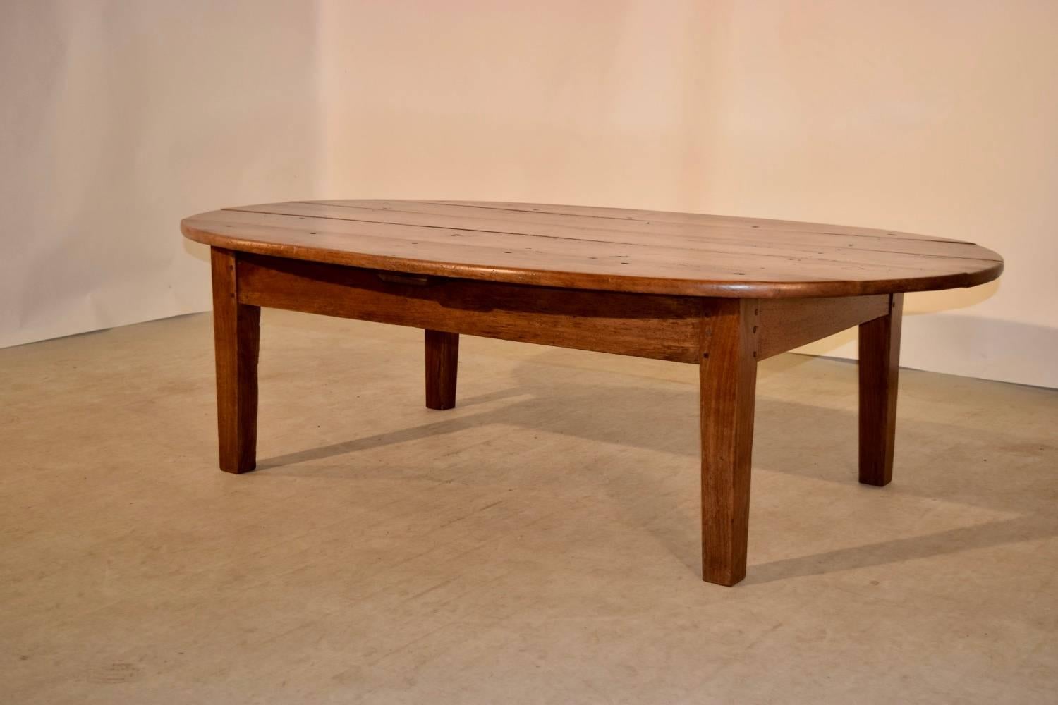 Early 19th century cherry coffee table from France. The top is made up of five planks, following down to a simple apron and raised on tapered legs.