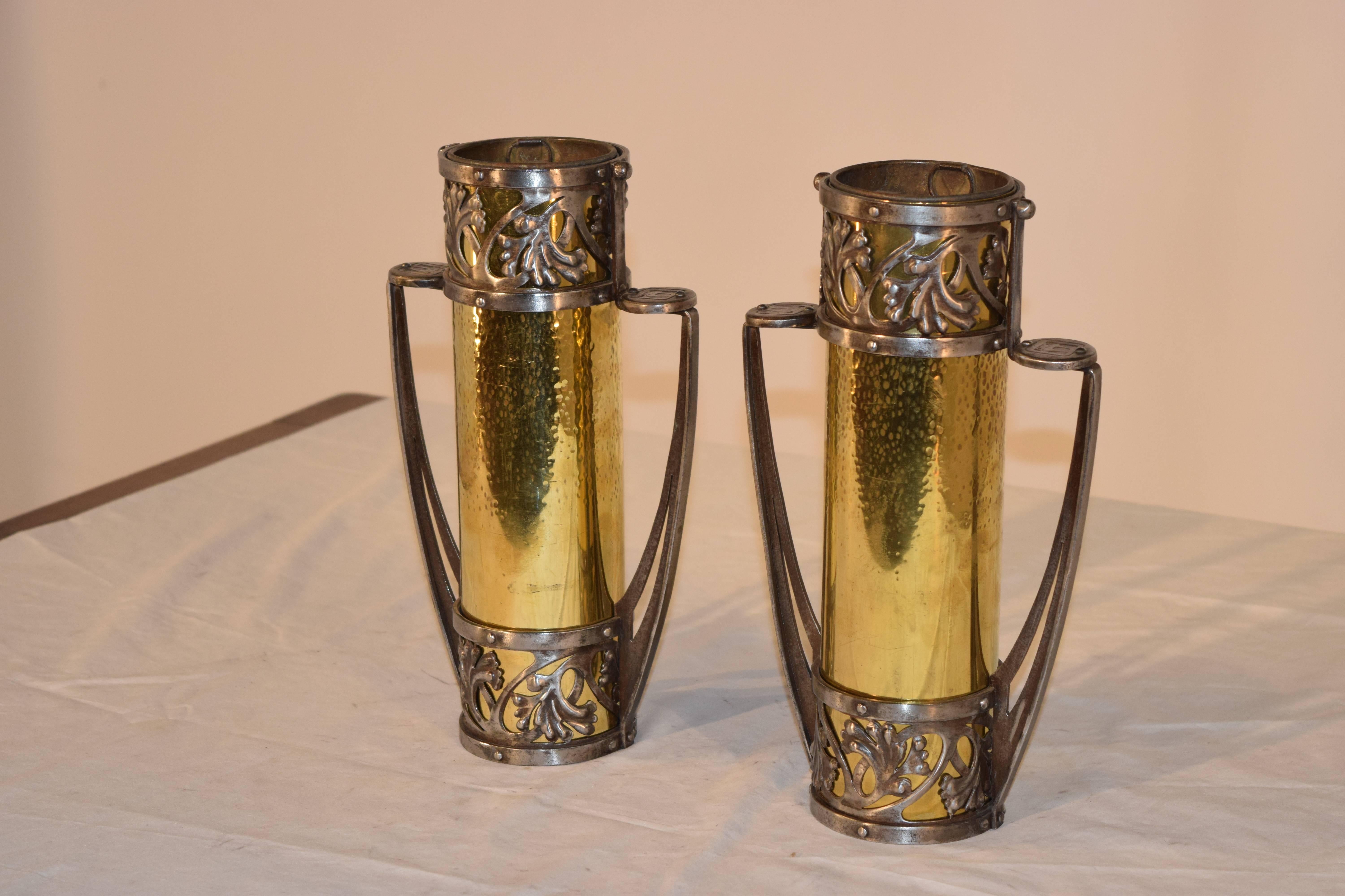 Pair of unusual 19th century vases from France. The frames are made from hand-forged iron and have hammered brass inserts.