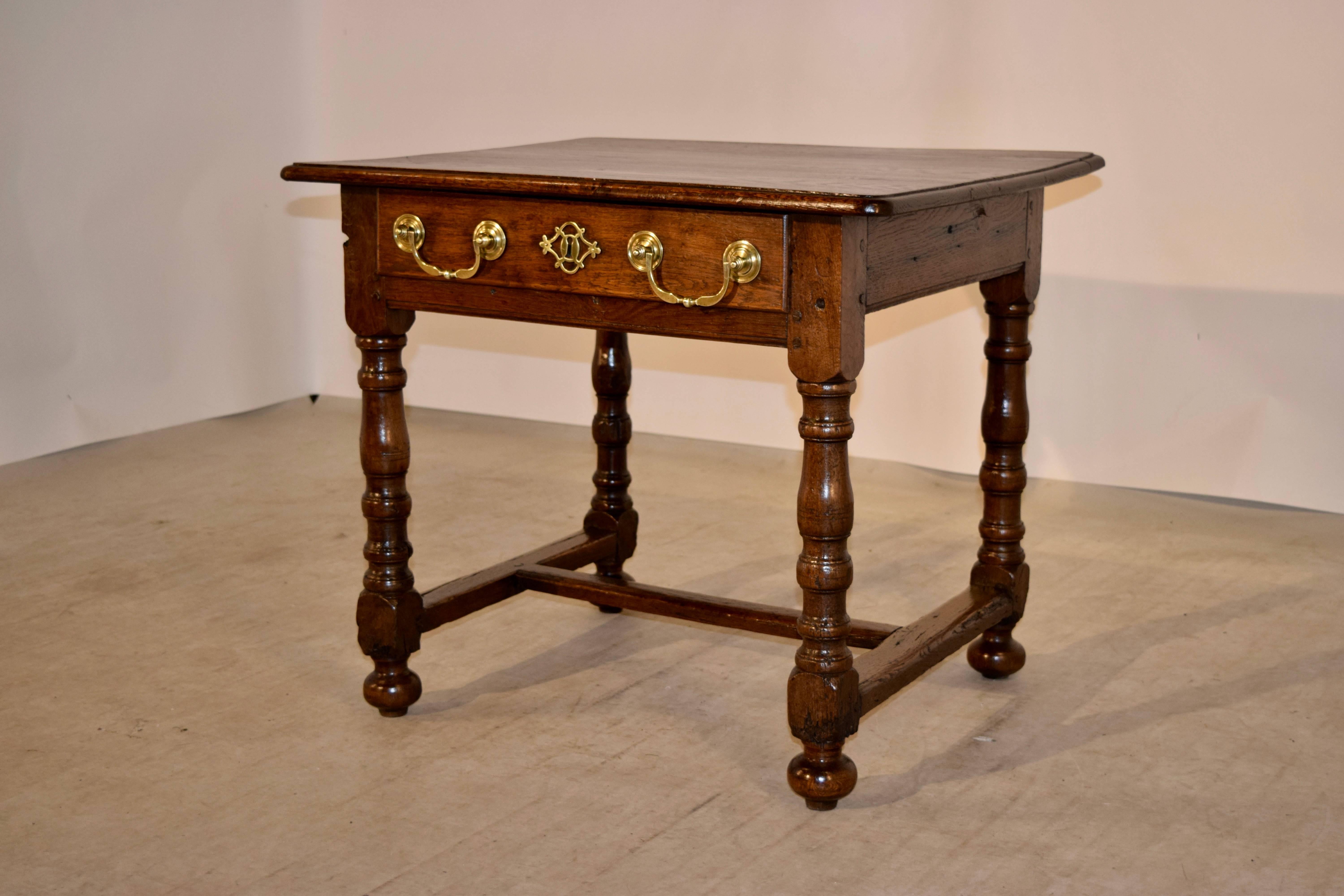 18th Century English side table made from oak with a beveled edge around the top, following down to a simple apron with a single drawer in the front.  The legs are hand turned and have signs of wear and age and the feet have been added later. 