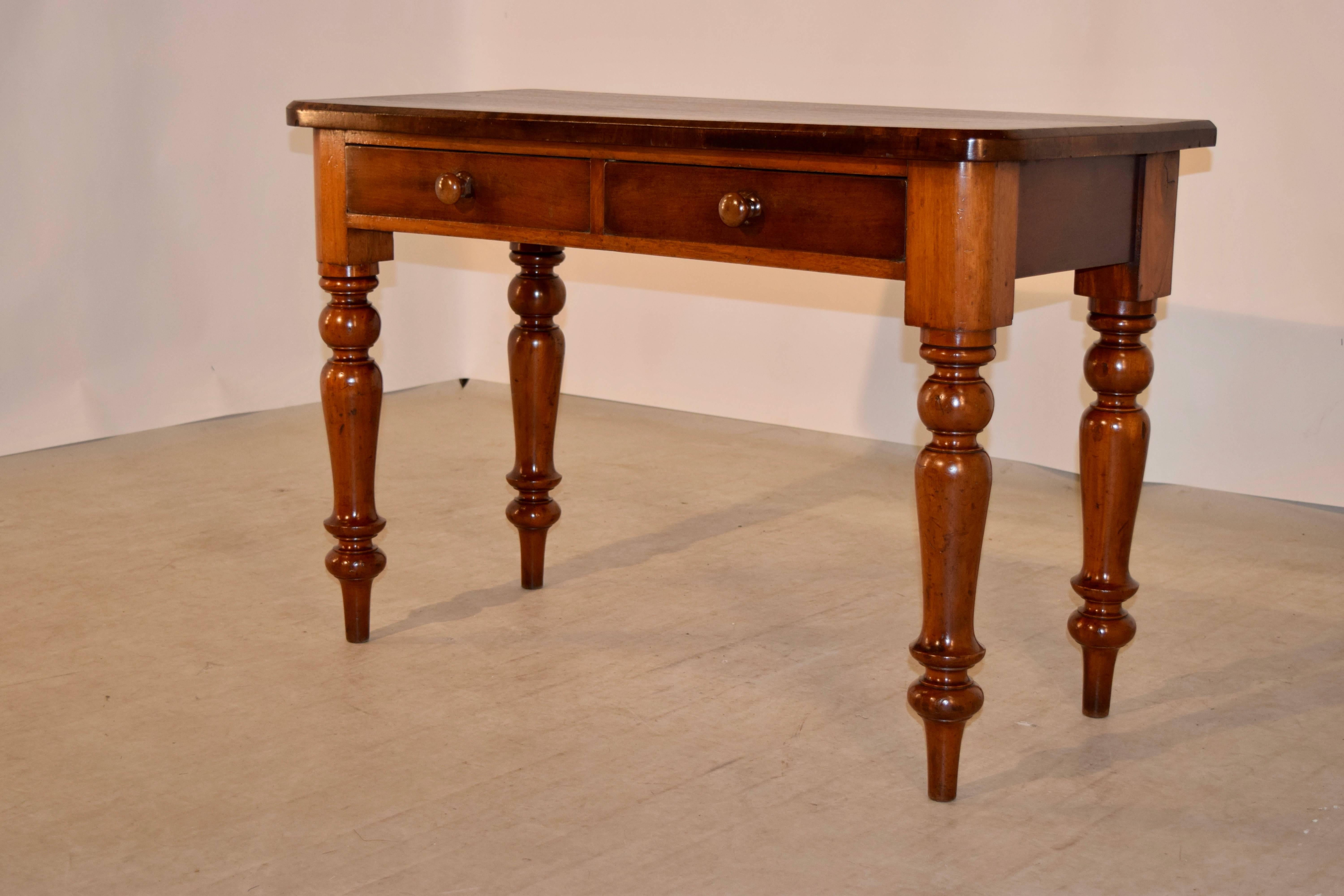 19th Century mahogany side table from England with a banded edge around the top, following down to two drawers in the front and simple sides.  The piece is raised on hand turned legs.  