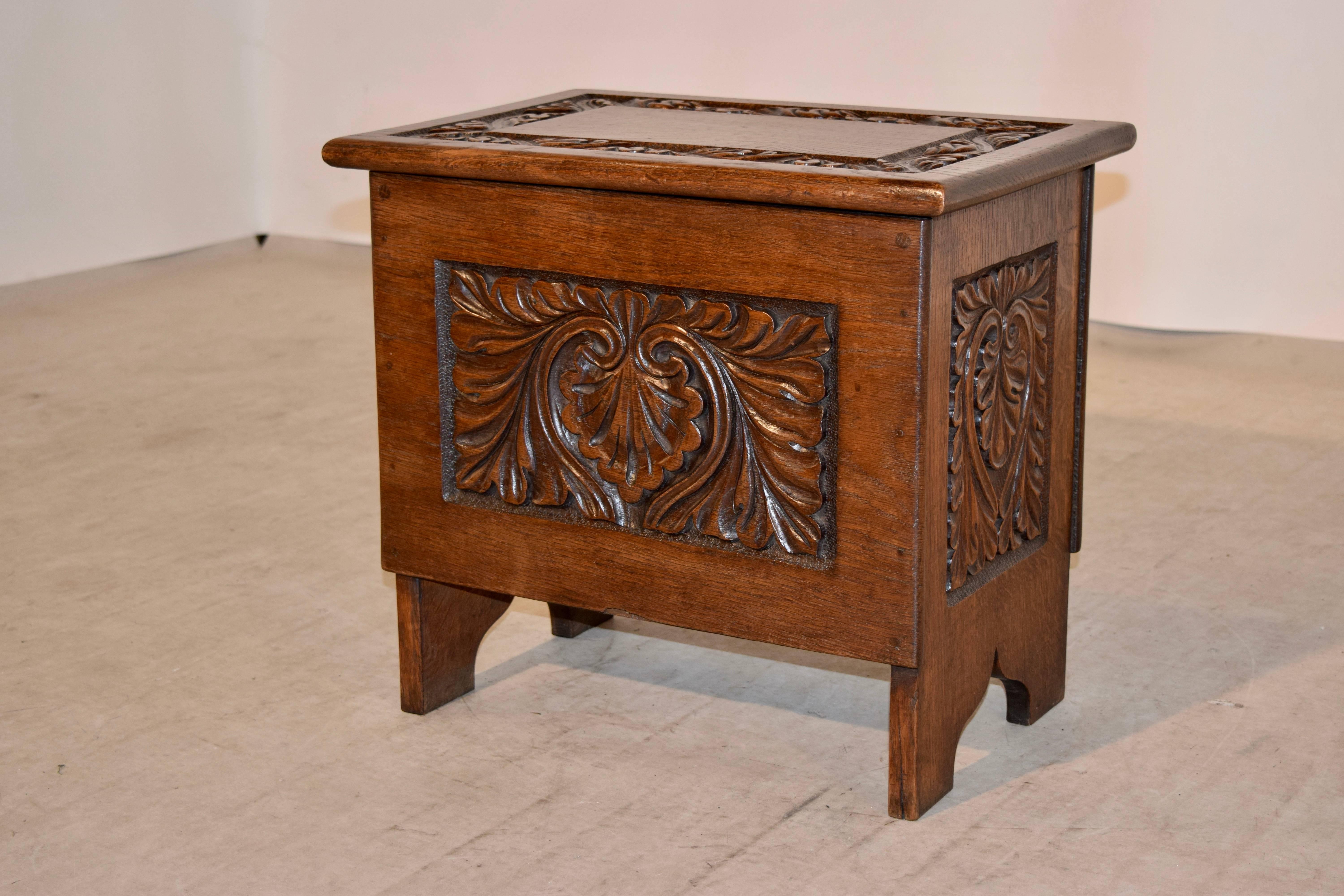 19th century English oak box with hand-carved panels on three sides. The top has a carved banded border, which lifts to reveal a deep storage compartment.