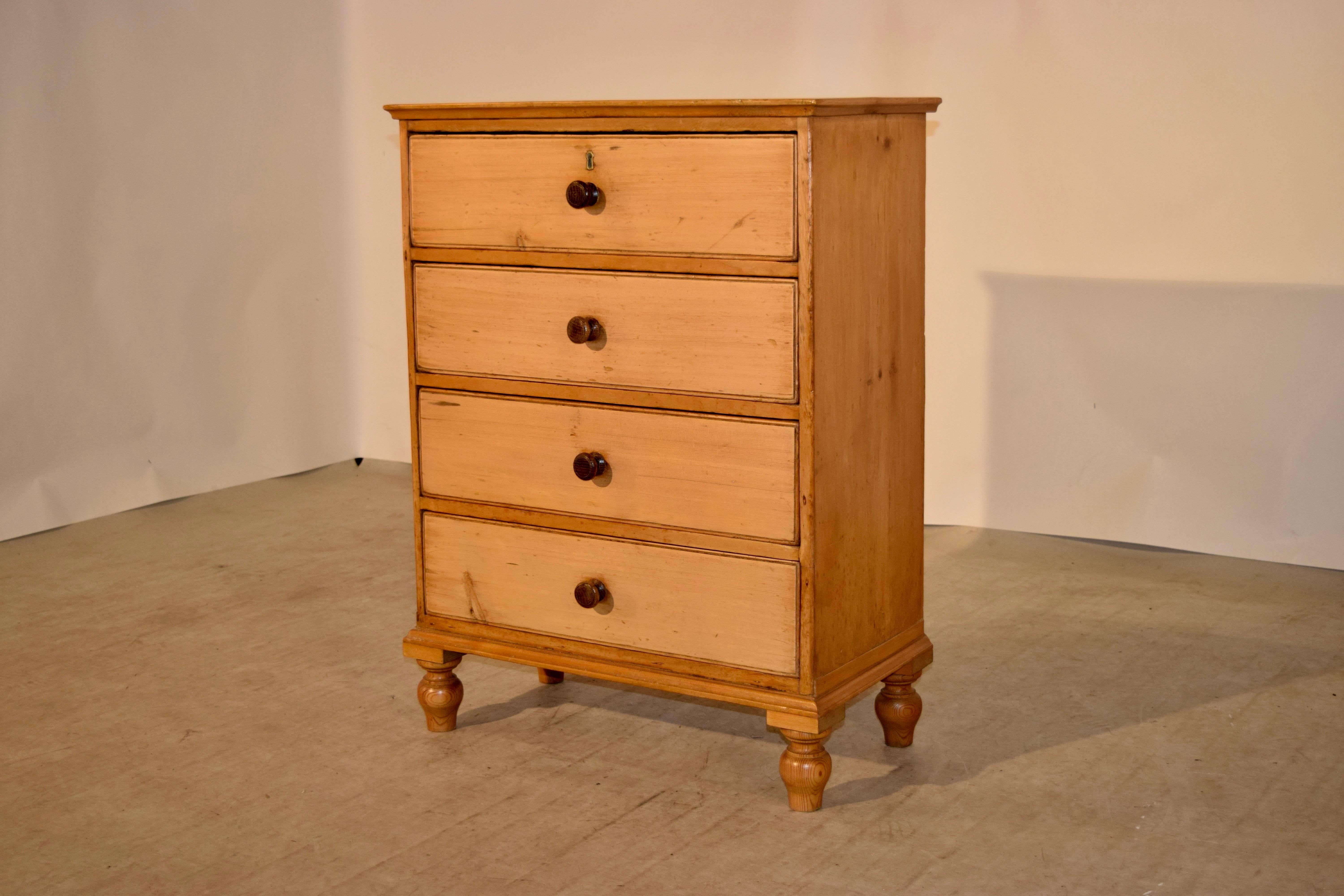 19th century small pine chest from England. The top is a single plank, which is banded, and follows down to four drawers and simple sides. Supported on hand-turned feet.