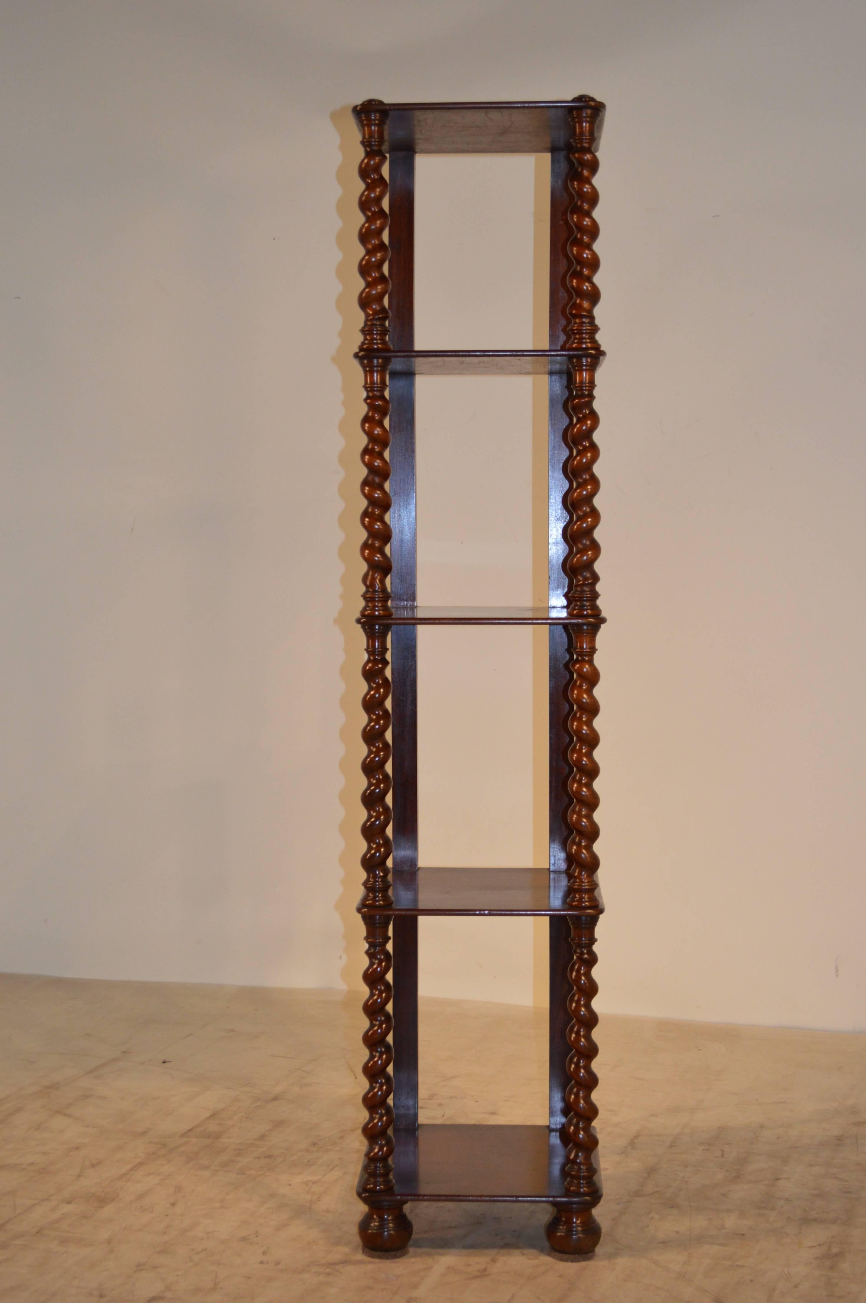 Mid-19th-century narrow English étagère with nicely hand-turned barley-twist shelf supports and turned feet. The back is flat for fitting against a wall. Age wear and shrinkage.
 