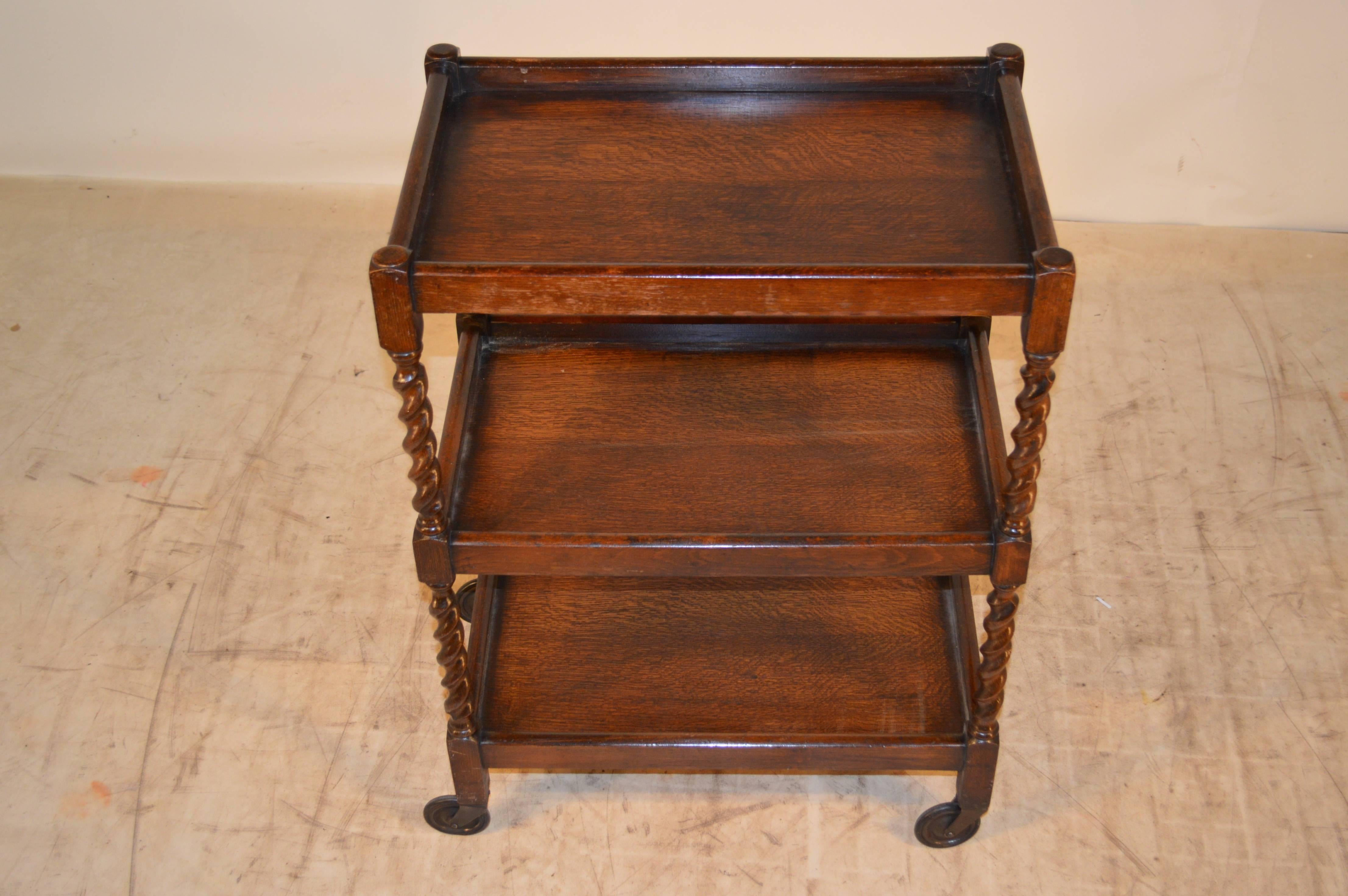 Circa 1900 English oak drinks cart with three shelves, which have galleries and barley twist shelf supports.