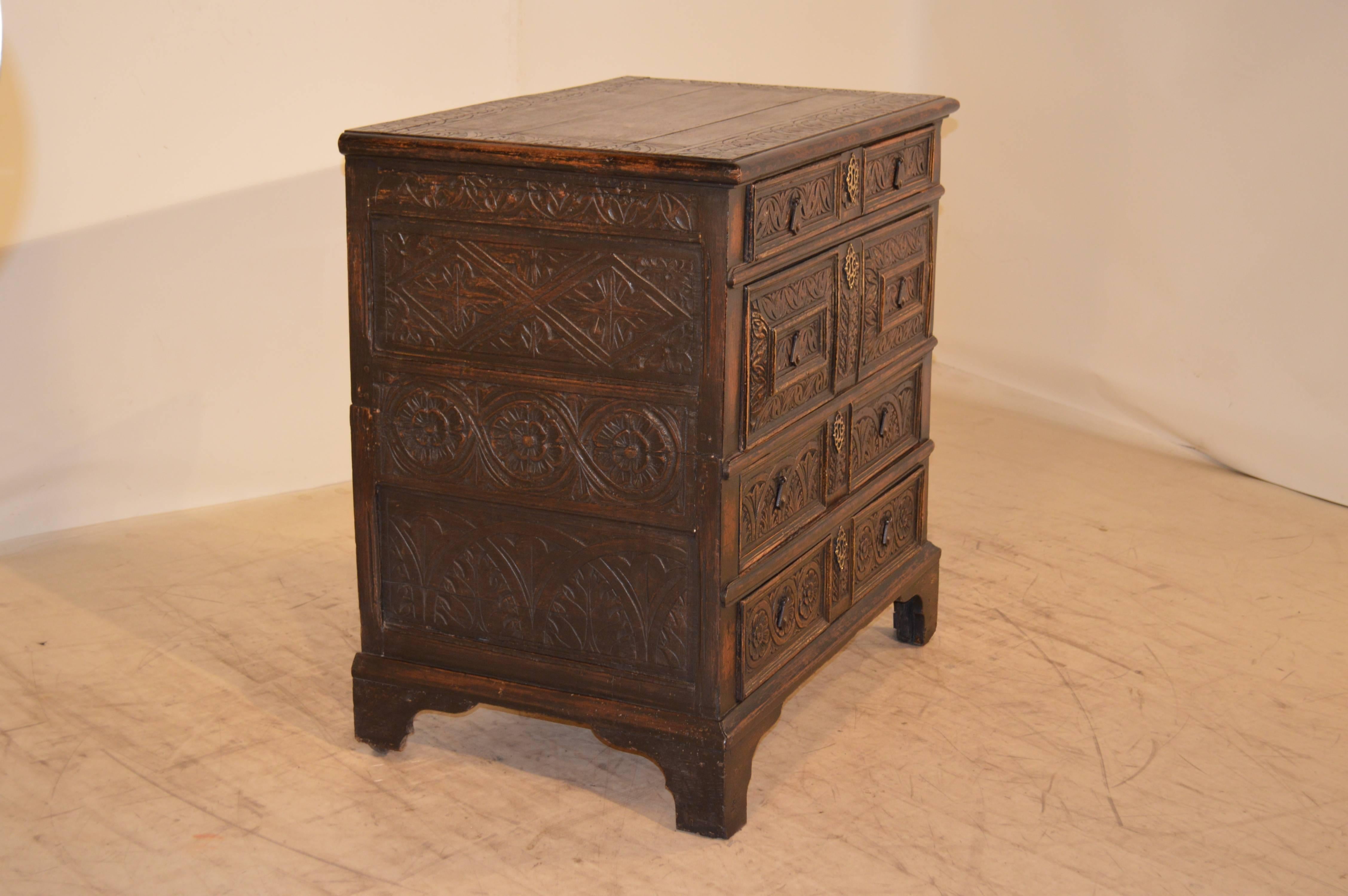 Late 17th- Century carved oak chest of drawers.  The top is made up of planks with a beveled edge and a carved banded top.  The case has paneled sides which are hand carved with wonderful decoration, and the front contains four drawers, which are