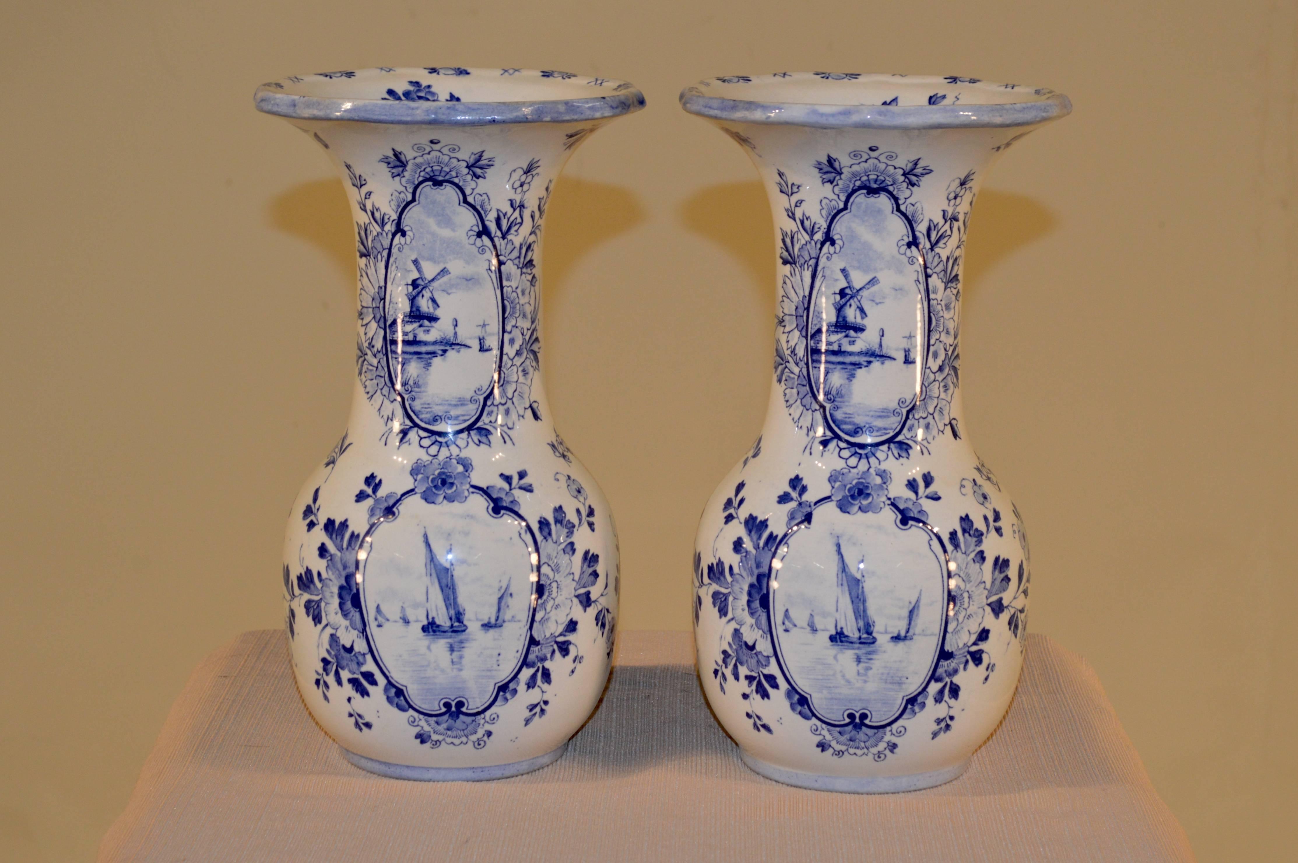 19th century pair of English vases in the delft style of the 18th century. They are distinctively marked on the bottom with an English date lozenge. It is unreadable but that dates it to the third quarter of the 19th century. The vases are