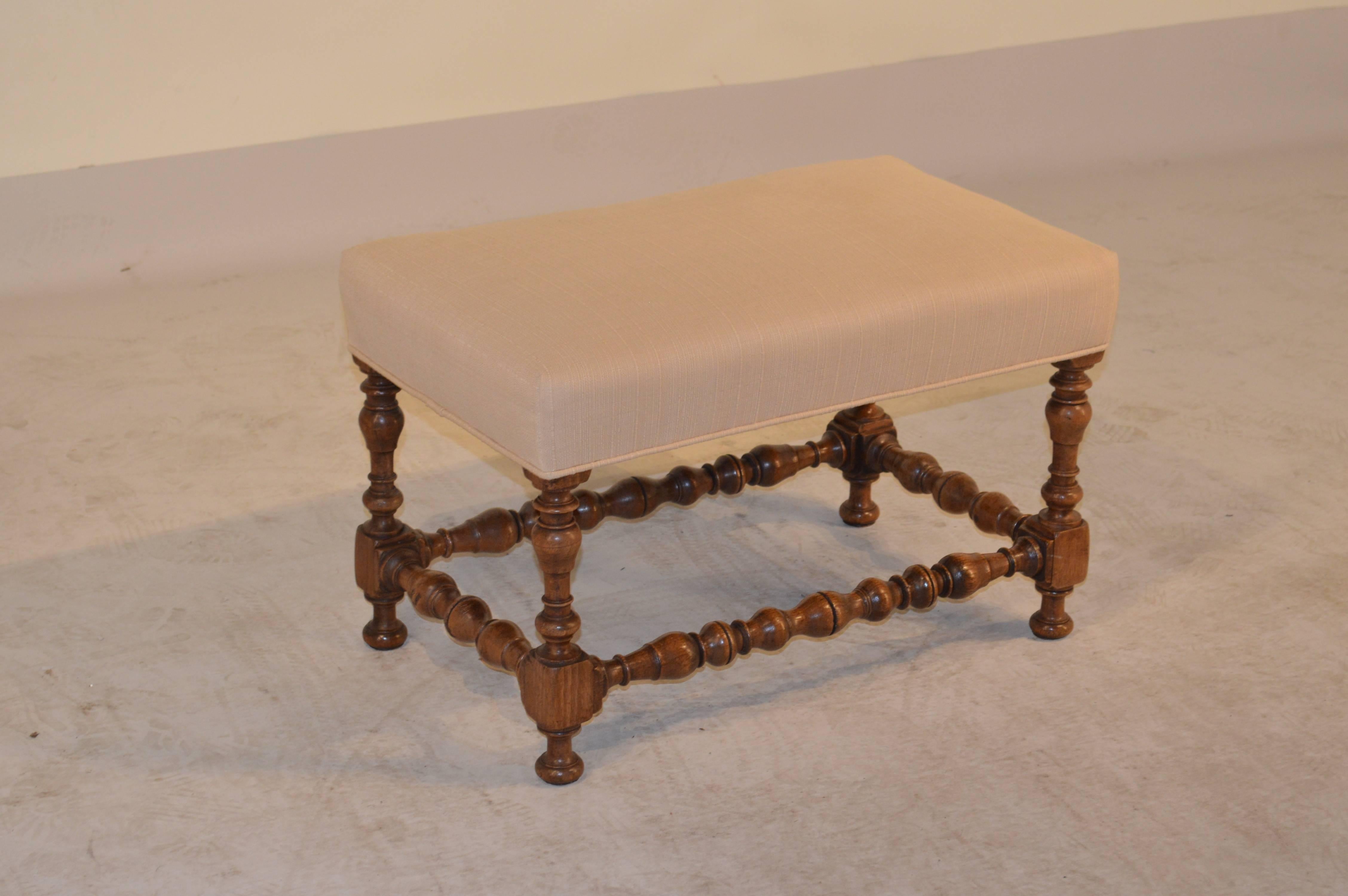 19th Century French turned oak bench with lovely shaped legs and stretchers and a newly upholstered top in linen.