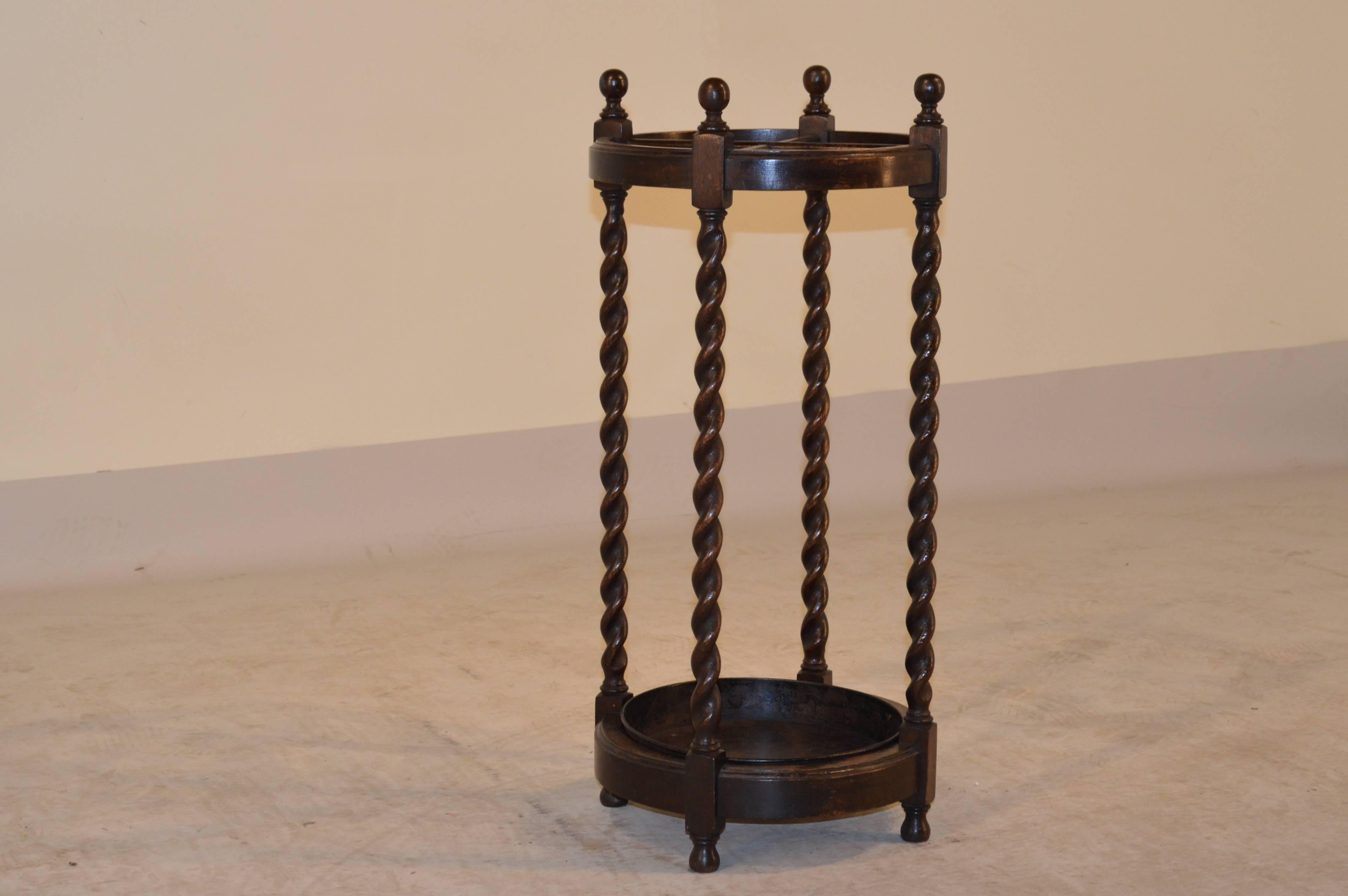 Late 19th Century English oak round umbrella stand with lovely hand turned barley twist legs.  It retains the original drip tray and is supported on turned feet.