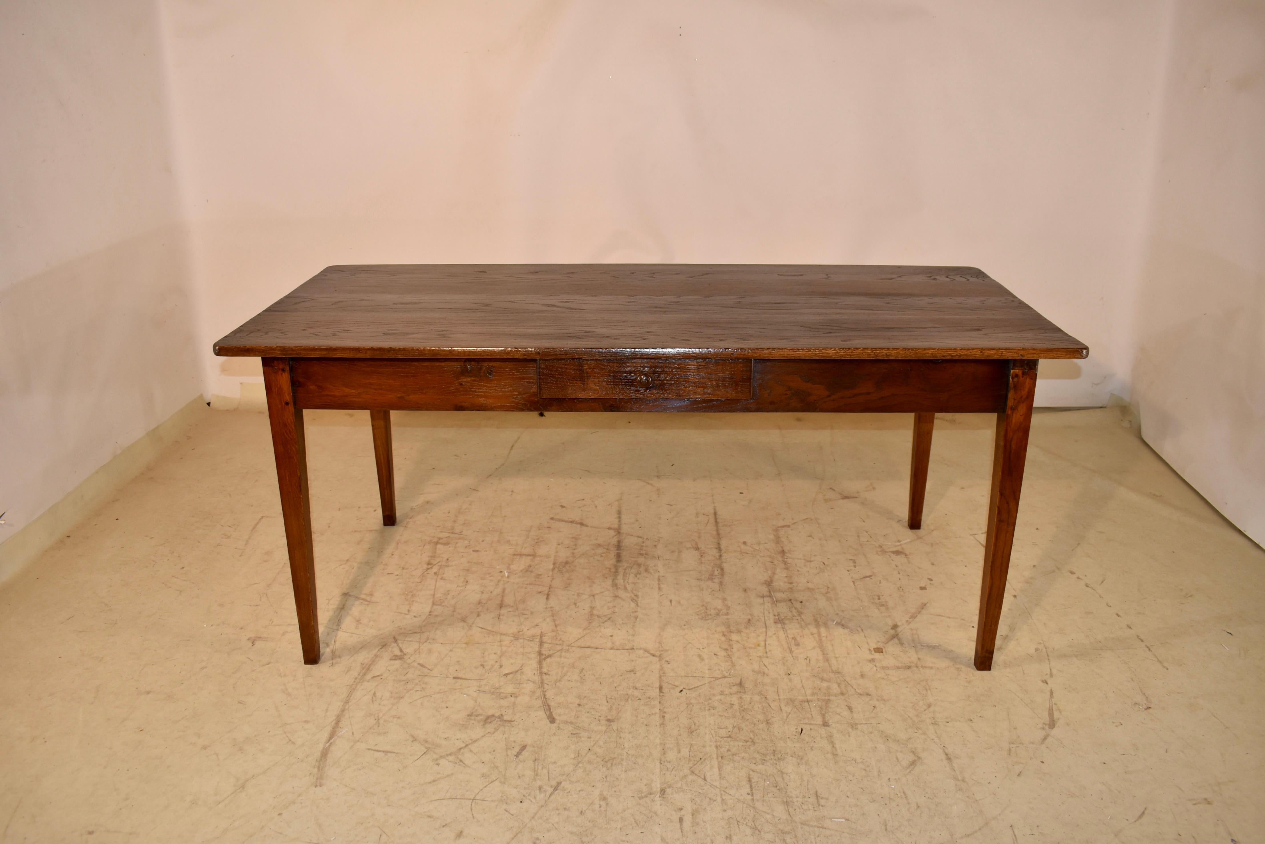 18th century chestnut farm table from France.   The top is made from wider boards with wonderfully grained old growth. The top  follows down to a simple apron, which contains a single drawer.  This gorgeous farm table is supported on hand tapered