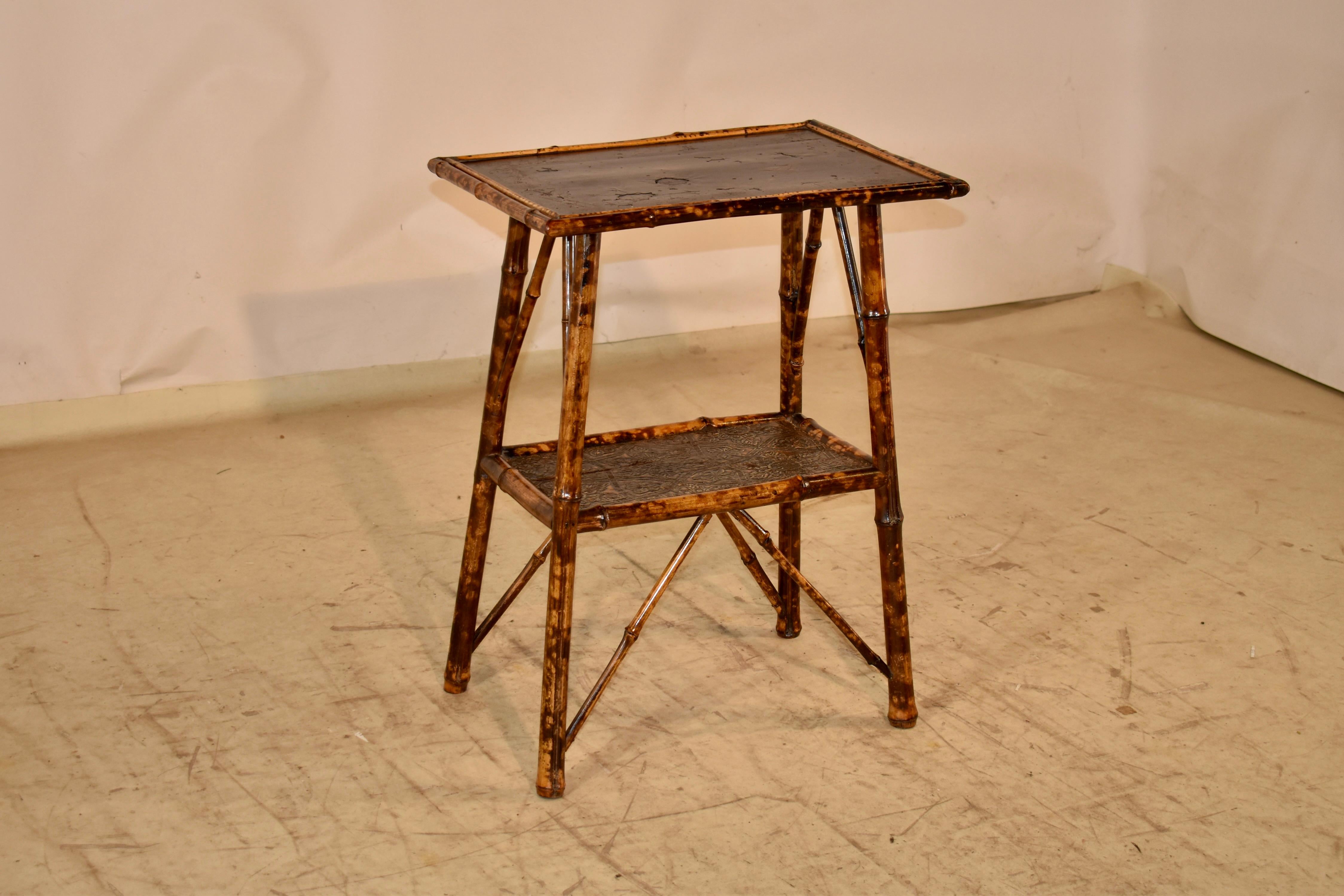 19th century tortoise bamboo side table from France.  The top has hand painted and lacquered decoration of birds surrounded by a border of florals.  The top is supported on splayed legs, The legs are connected at the bottom by a lower shelf, which
