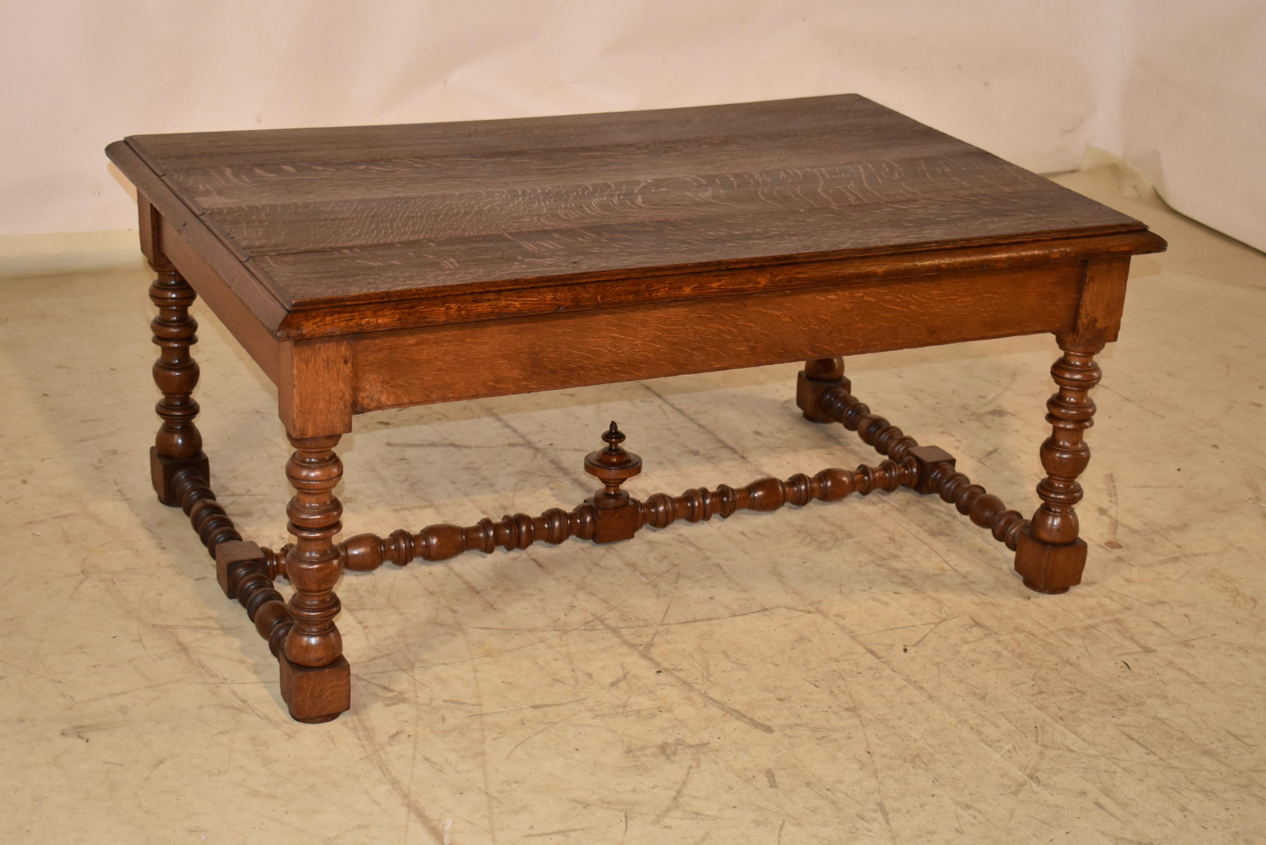 19th century oak coffee table from France.  The top is made from four boards and has nice graining.  The top is surrounded by a molded and thick beveled edge, which adds stature to the table.  The top follows down to a simple apron, containing two