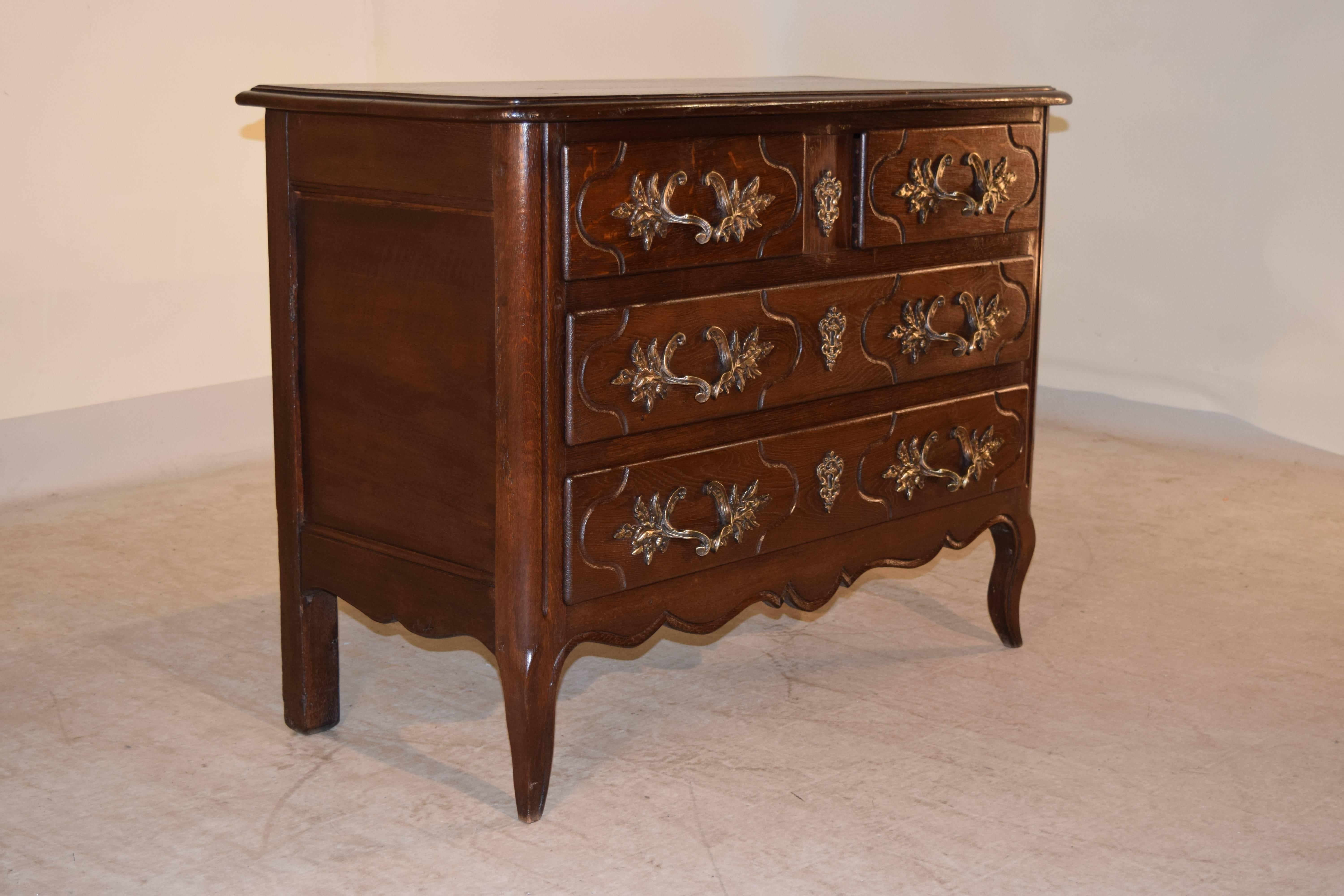 French oak chest in the Louis XV style, circa 1900. The top is beveled around the edge following down to two over two drawers configuration. The apron is scalloped and beveled and the sides of the case are raised paneled and are supported on lovely