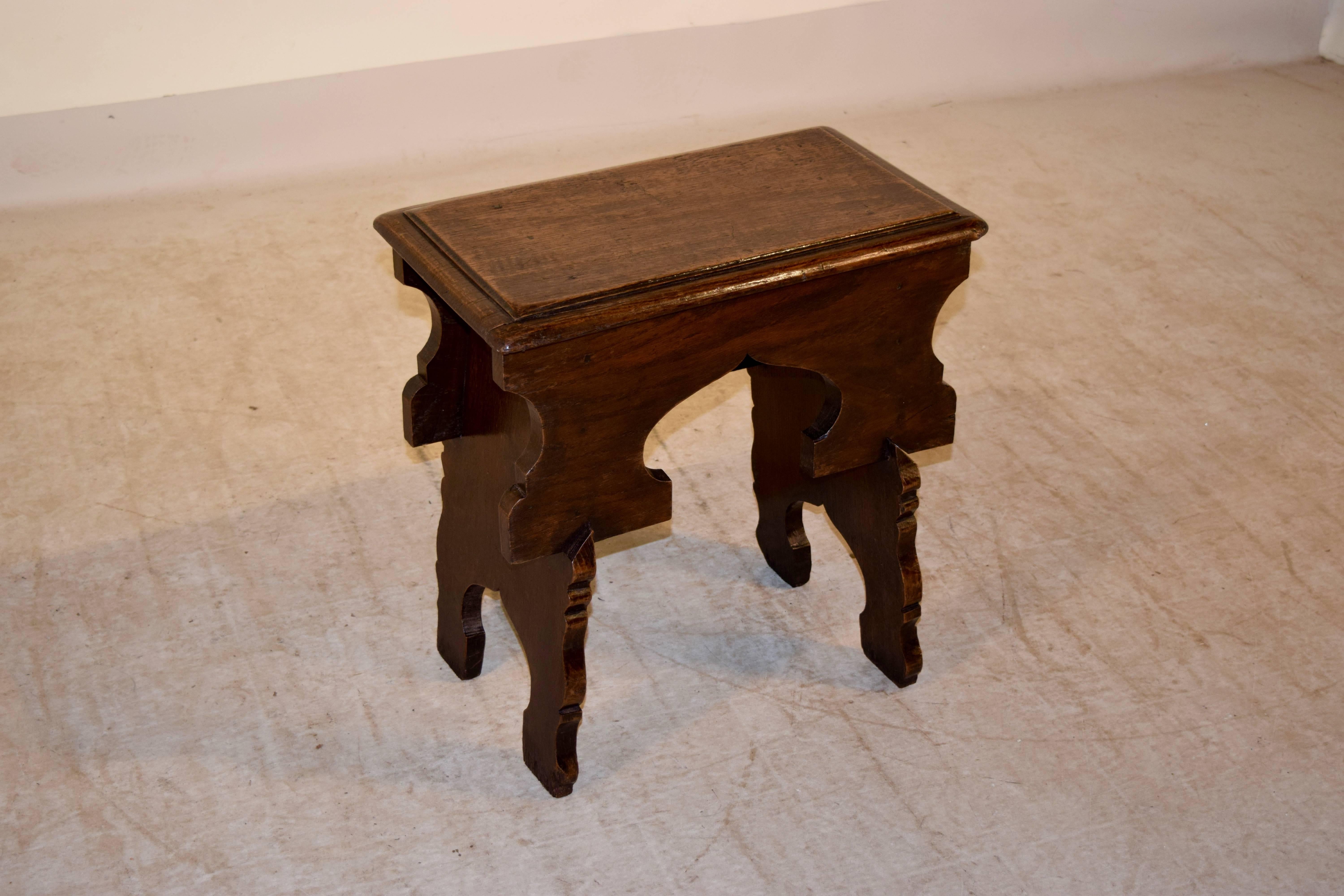 Mid-18th century oak stool from Wales. The top is beveled and follows down to a wide apron, which is shaped and fits into the legs, which have mirrored shapes. This is a very unusual and unique piece.