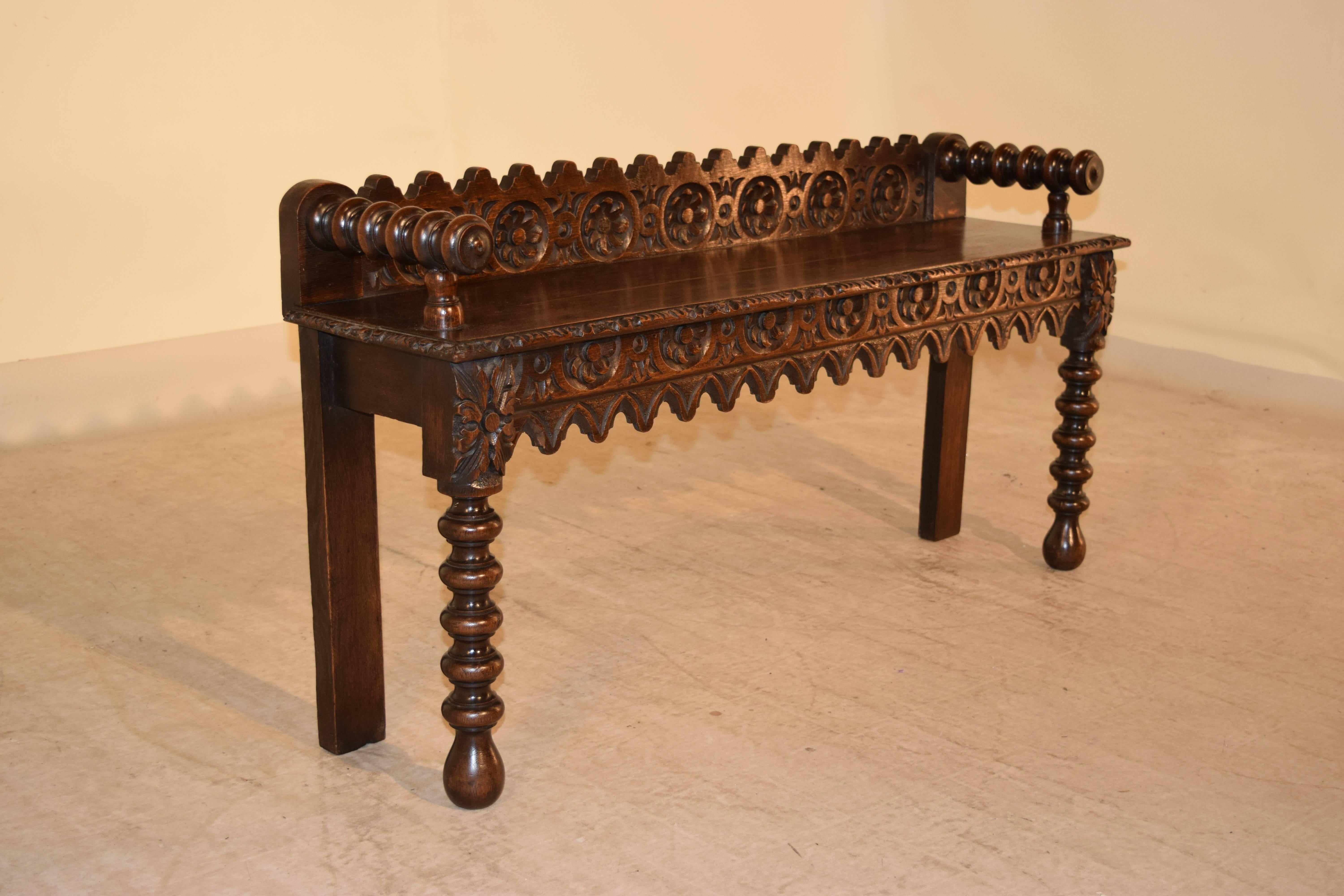 19th century English oak window seat with hand-carved back and apron and hand-turned arms and front legs. Seat, 19.25