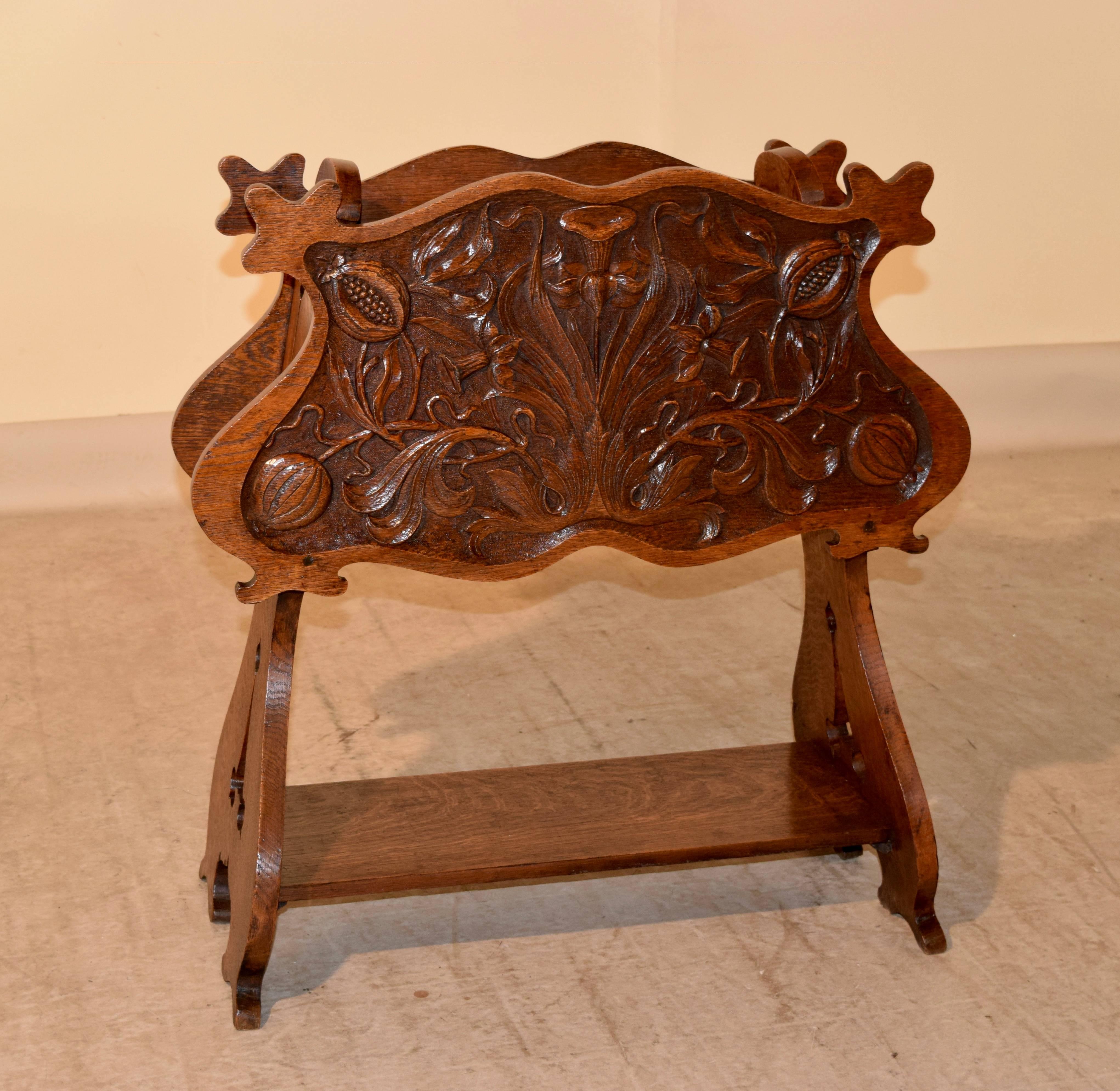 19th century French magazine rack made from oak. The front and back panels are fabulously hand carved with wonderful floral patterns, and are shaped as well. There are two central sections inside for magazines or papers. The sides are pierced and