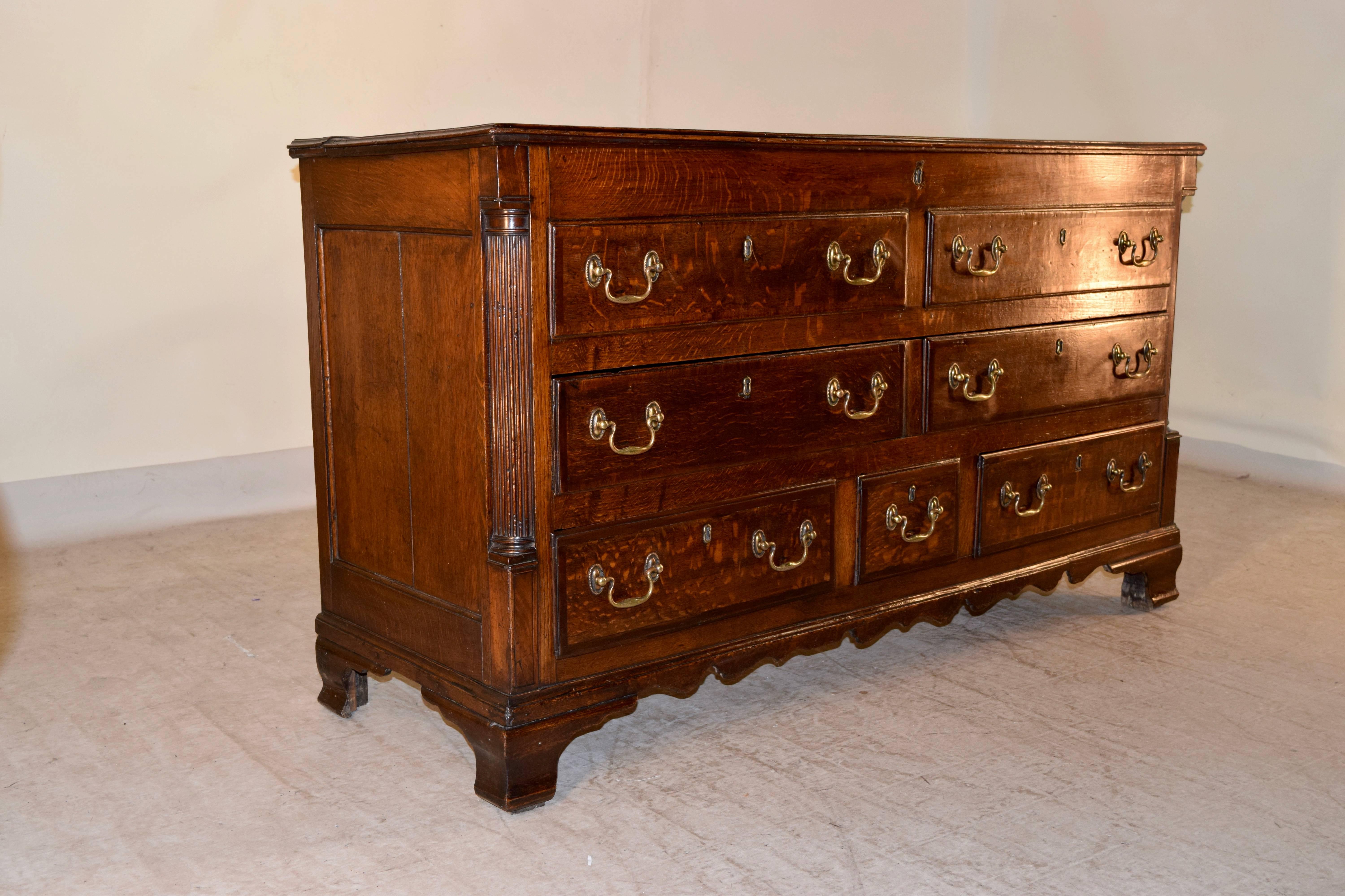 Early 19th century Lancashire mule chest which has been converted to be a chest of drawers with a lift top. The top and drawer fronts are banded in mahogany and the top has a molded edge. There are seven drawers in the case, flanked by fluted column