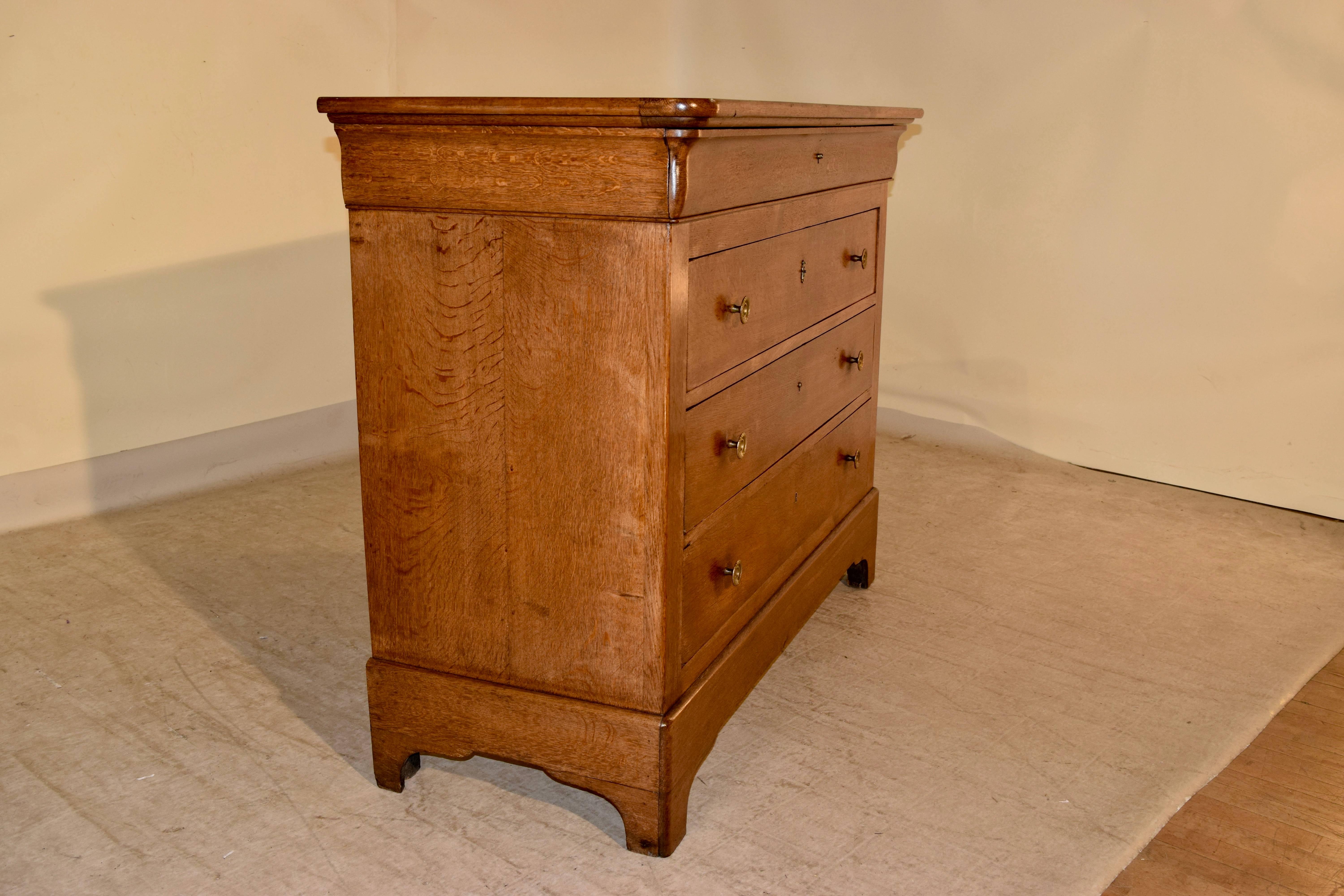 19th century Louis Phillipe commode in oak. The top is banded around the edge, following down to a single drawer hidden in the top molding and three lower drawers. Raised on bracket feet. Slight chip on lower drawer.