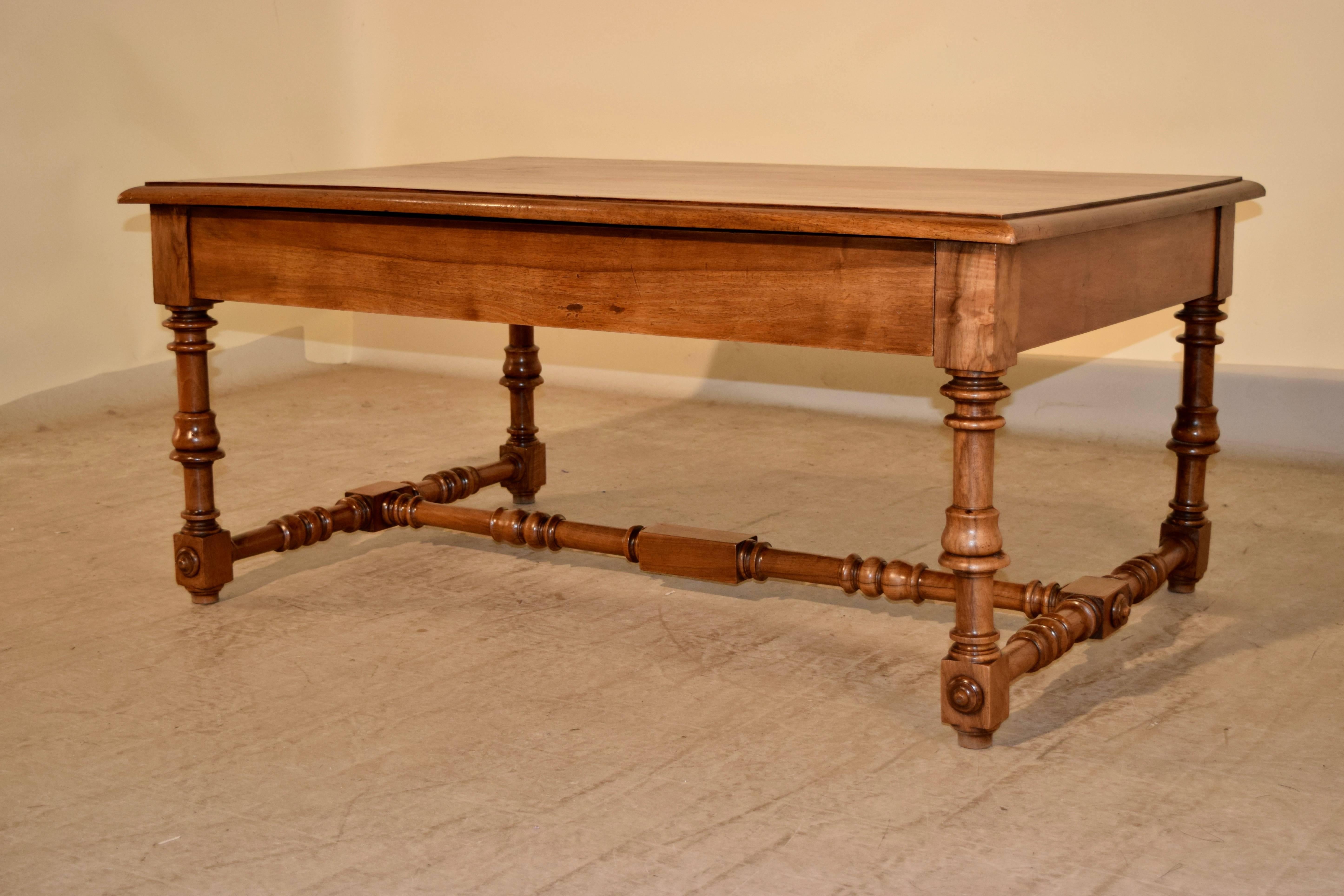 19th century walnut coffee table from France with a beveled edge around the top, following down to a simple apron which contains a single long drawer in the front. The legs are wonderfully hand-turned and are joined by a hand-turned stretcher.