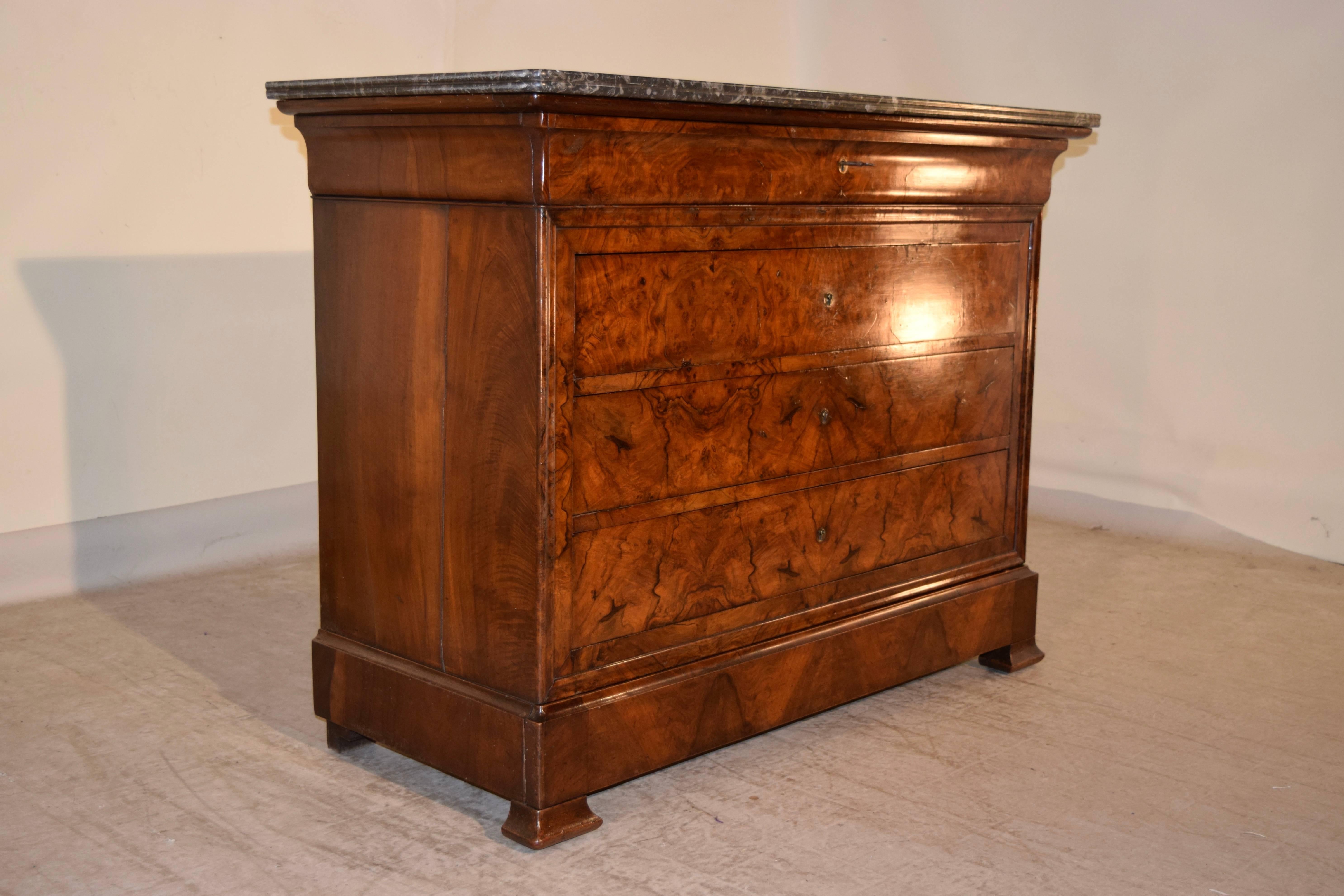 19th century Louis Philippe commode with a removable marble top, following down to a drawer, which is concealed in the molded top and three other drawers below. The piece is made of burl walnut on the front and simple walnut on the sides. Raised on