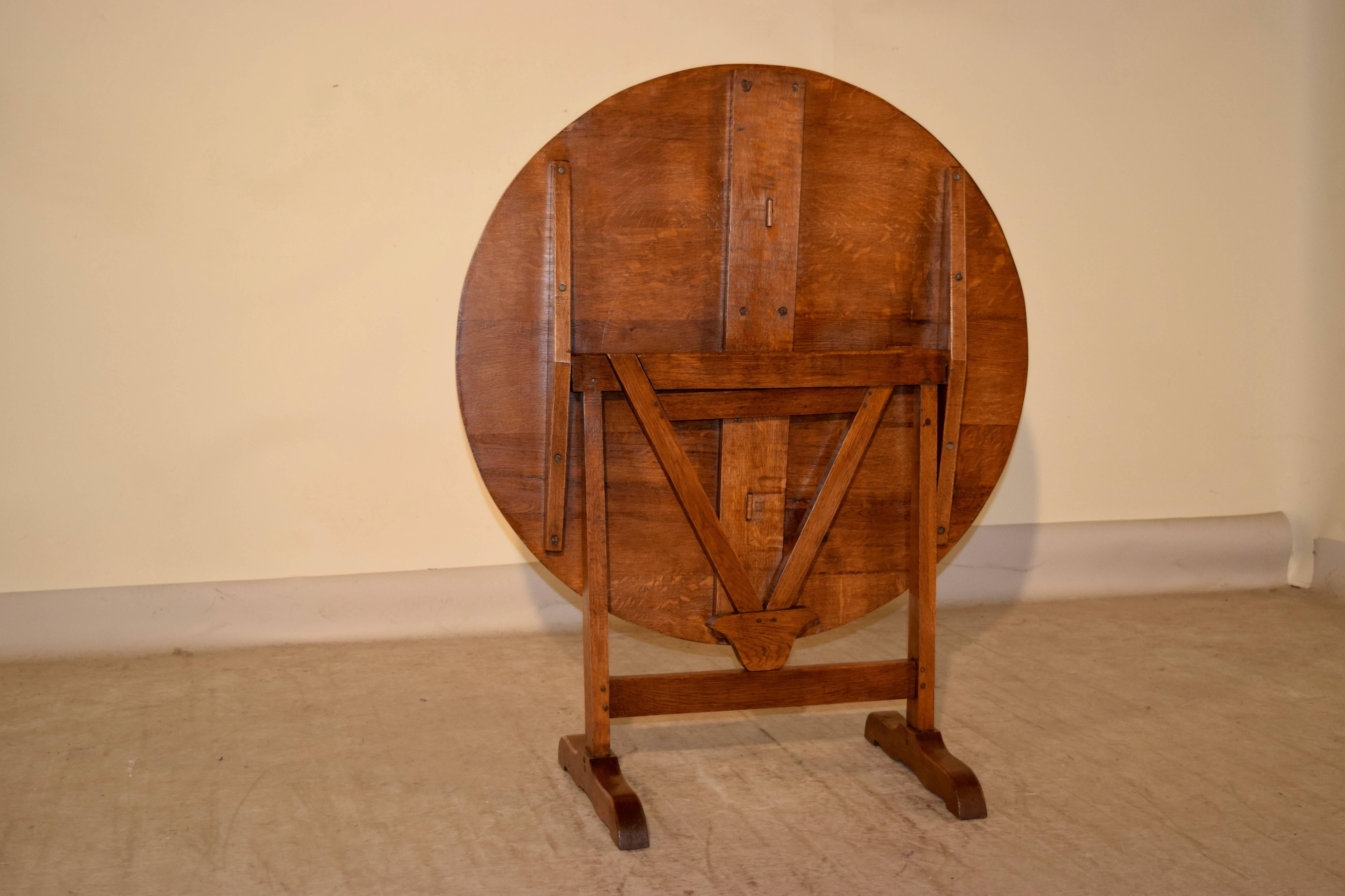 19th century French wine tasting table made from oak. The piece has simple stretchers and a simple trestle base, supported on shaped feet. The top open measures 35.5 x 35 x 28.25.