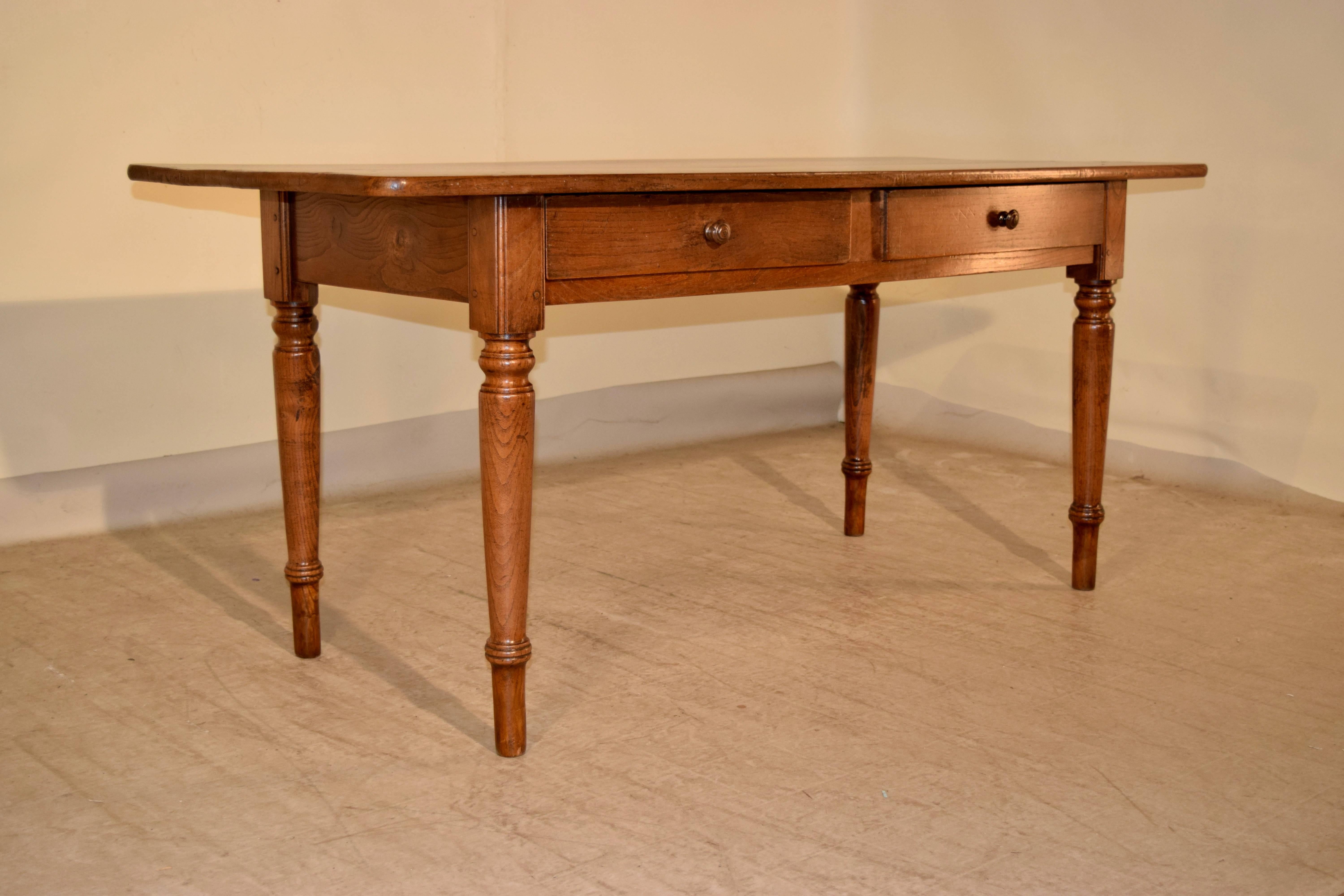 19th century French desk made from oak with a two plank top which is wonderfully grained, following down to a simple apron which contains two drawers in the front supported on hand-turned legs. The apron measures 24.13 H.