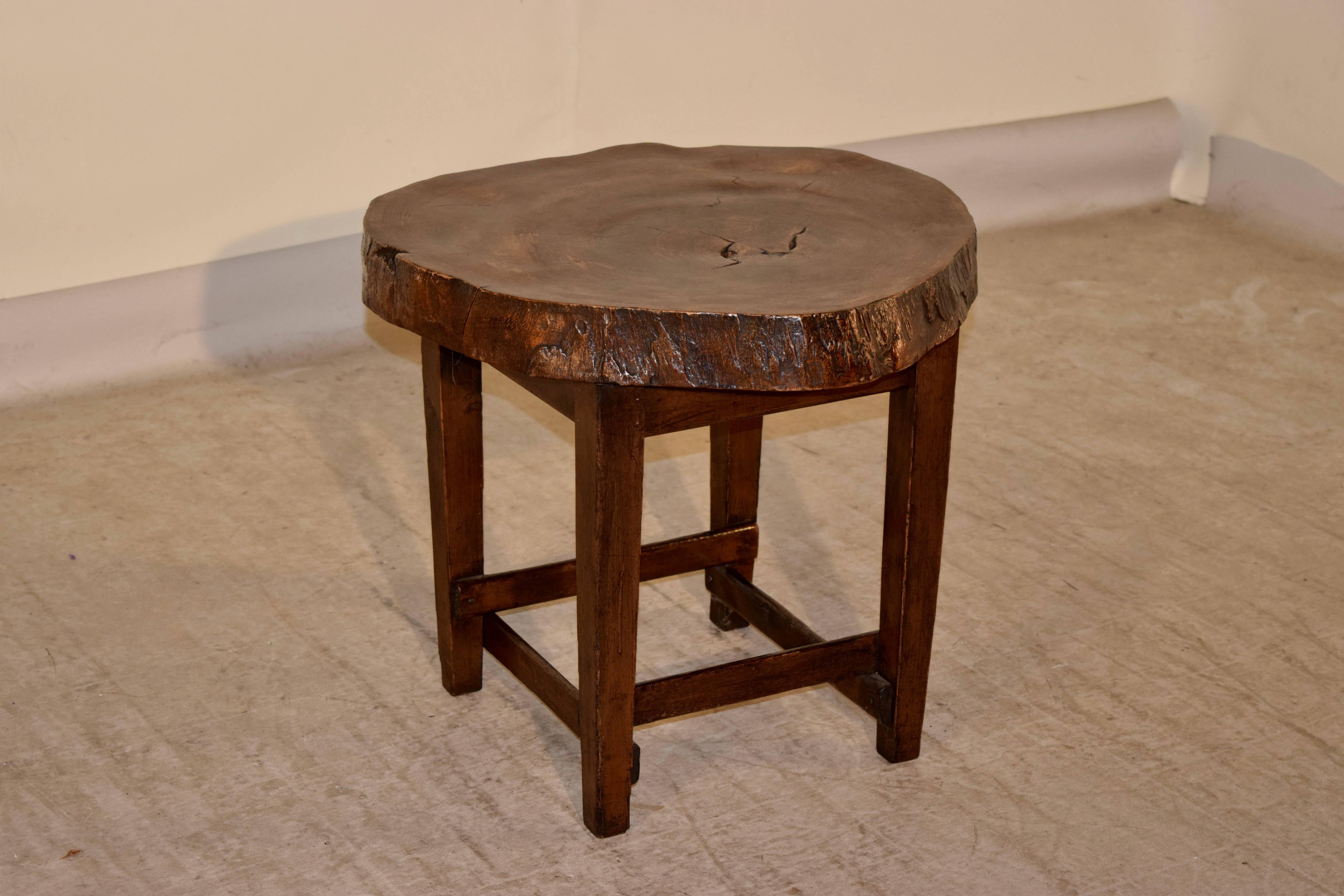 1950s walnut live edge side table from England. The top is a 3 inch thick slice from a walnut tree, supported on simple legs, joined by cross stretchers for stability.