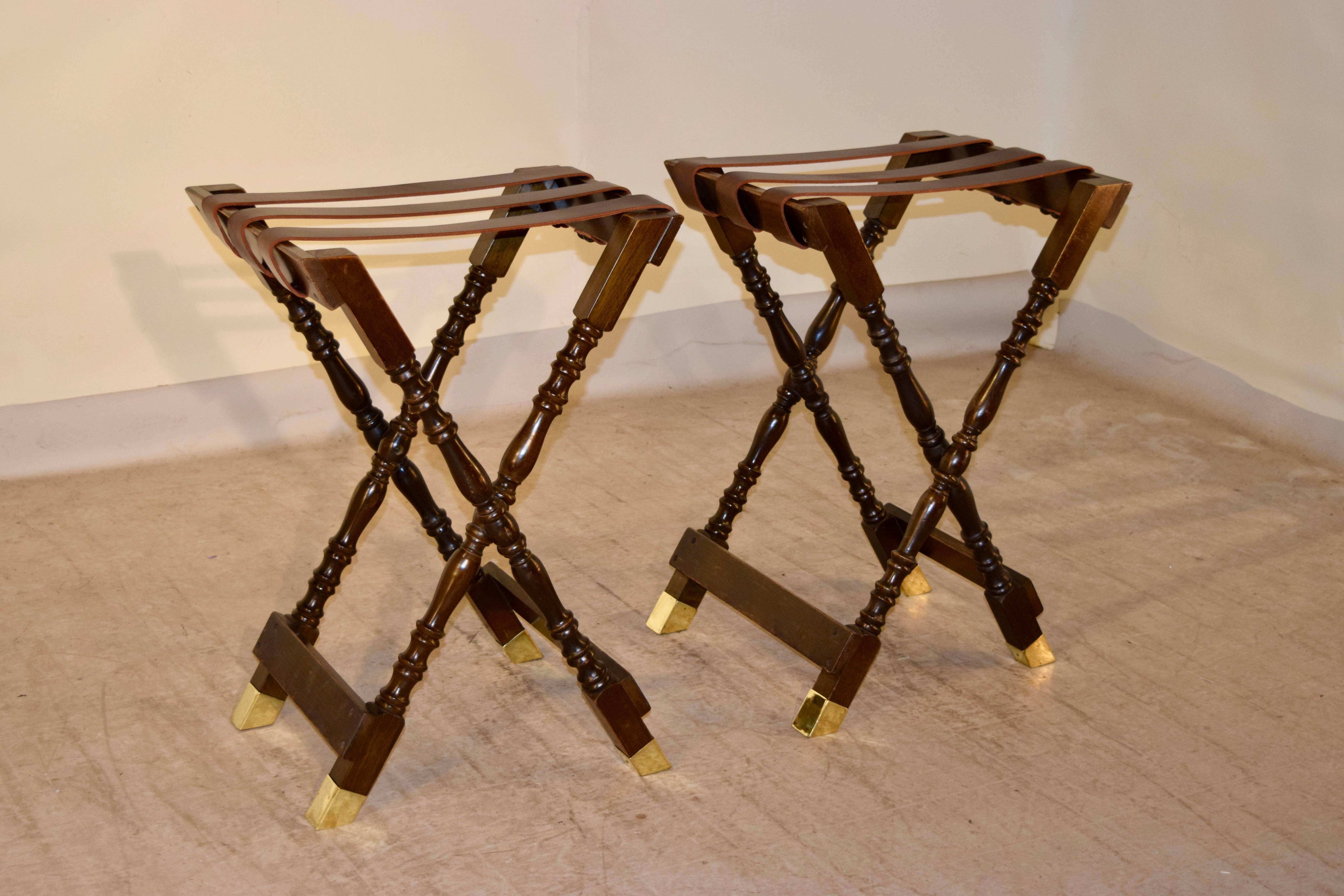 Pair of mahogany tray stands from England, circa 1920. The frames are hand-turned and have leather straps on the top and the feet are capped in brass. The stands open measure 21.25 W x 18.13 D x 30.25 H.
