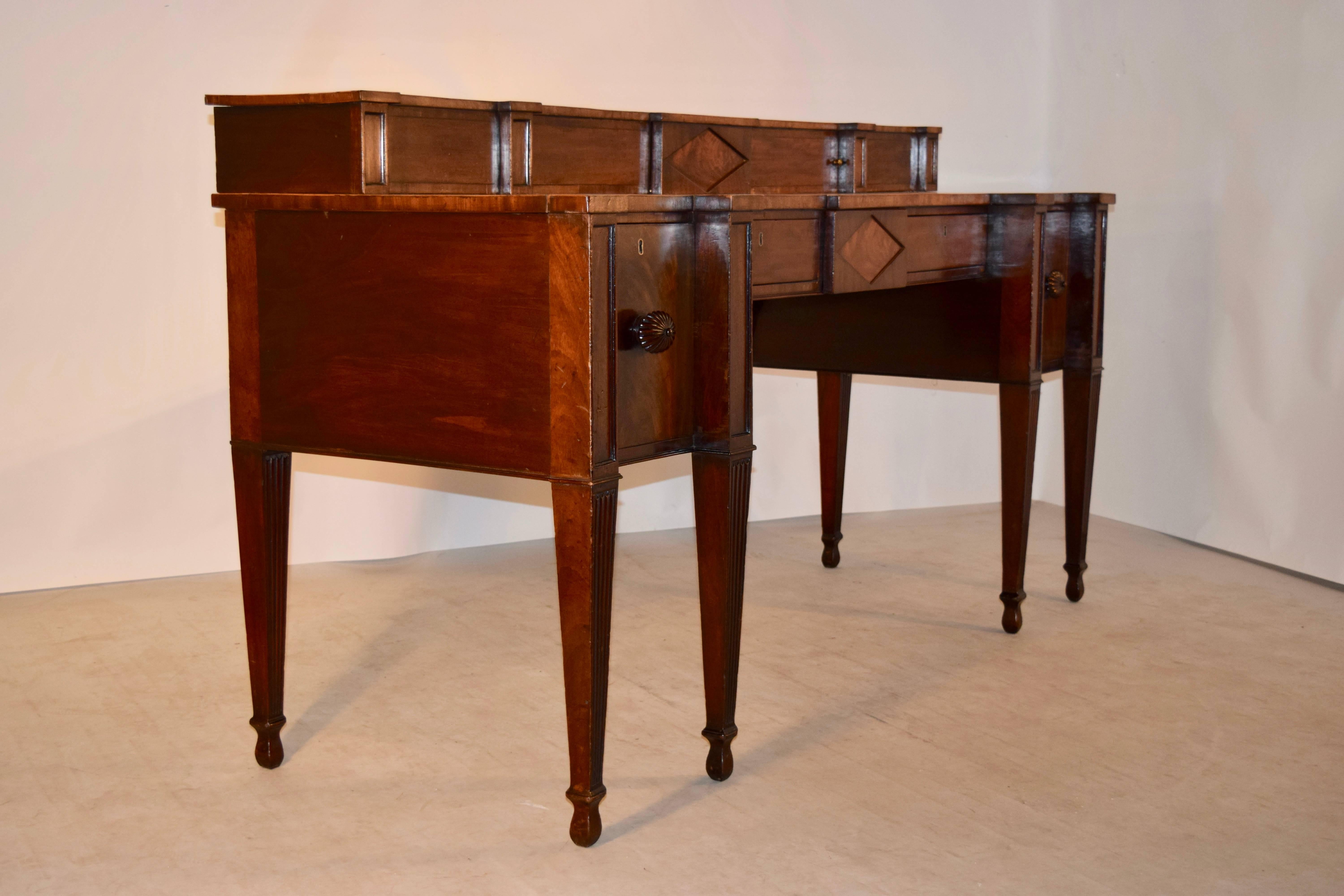 18th century Georgian mahogany sideboard with stepped back. There are two sliding doors on the upper part of the sideboard, following down to a wonderfully grained surface. There are two central drawers, flanked by two cellarette drawers, one of