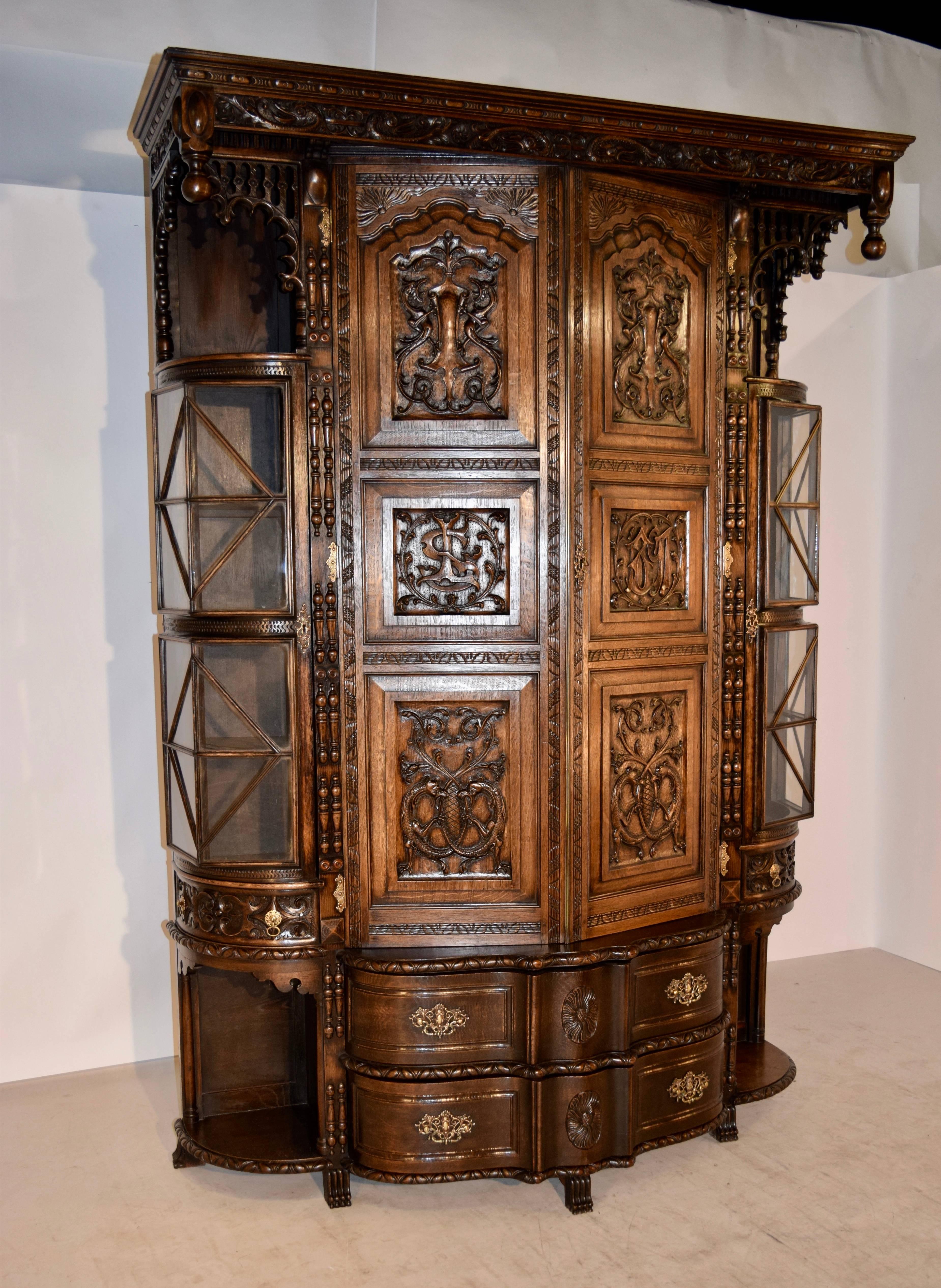 Late 19th century English cloak cupboard made from oak. This piece is exquisitely carved in detail. The crown is molded with egg and dart detail and wonderfully carved dolphins, embellished with hand-turned finials. On the sides, there are Gothic