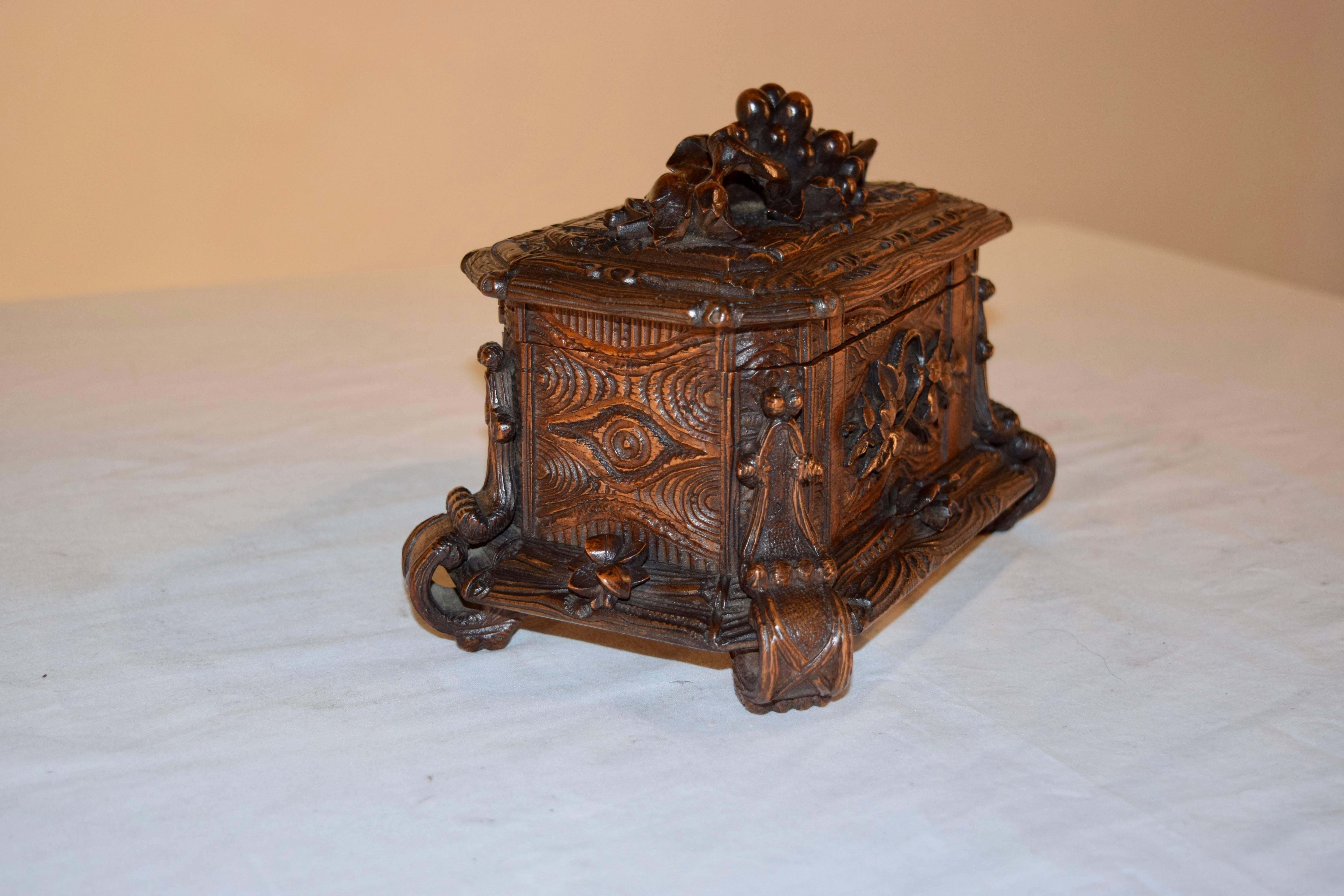 19th century Black Forest carved box with gorgeously carved sides and top. The box has patterns of straps and wood patterns, decorated further with grapes, twigs, and leaves. It retains the original velvet lining. No key is present.