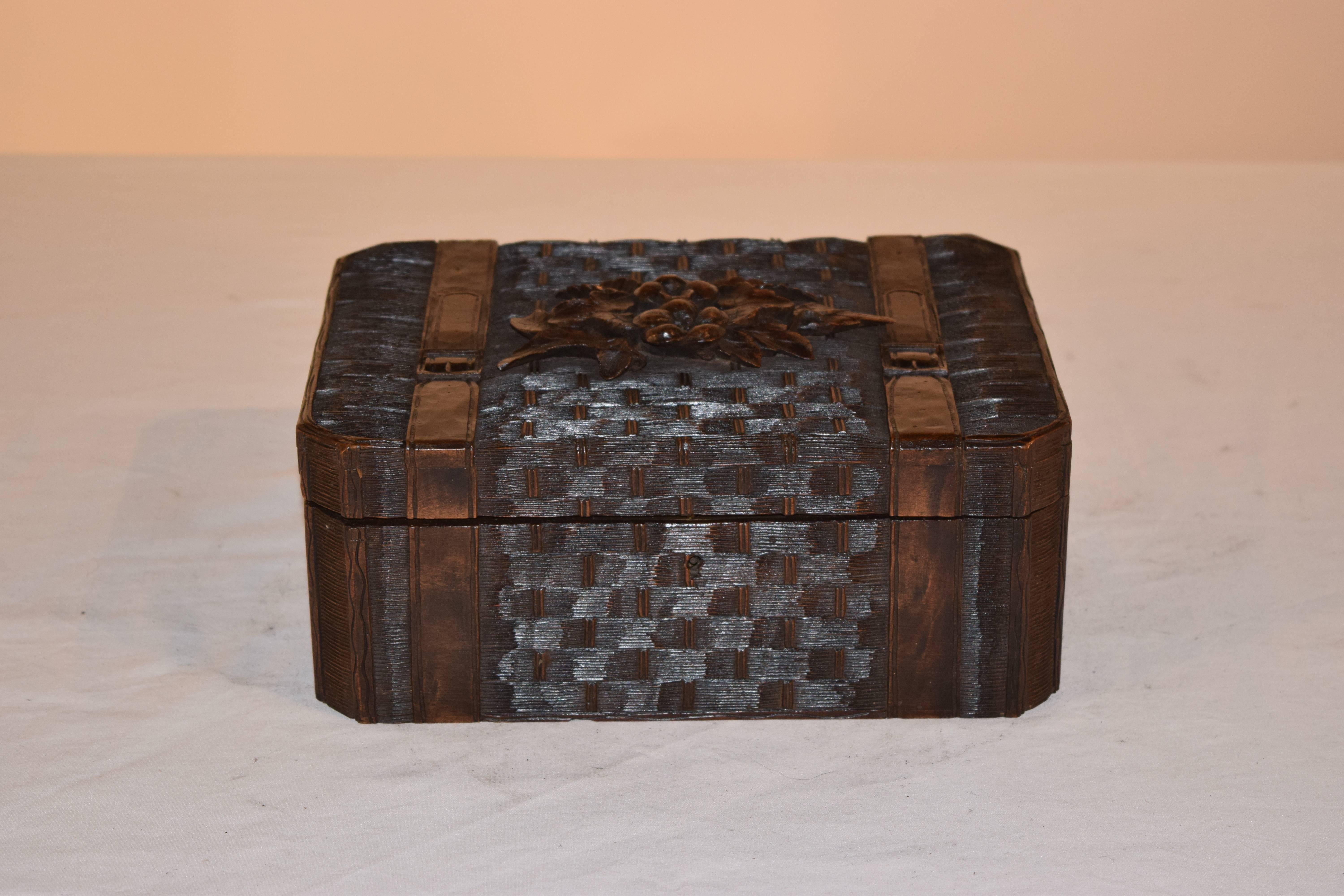 19th century dresser box carved in a basketweave pattern with luggage straps seemingly holding it closed. This is an excellent example of Black Forest carving.