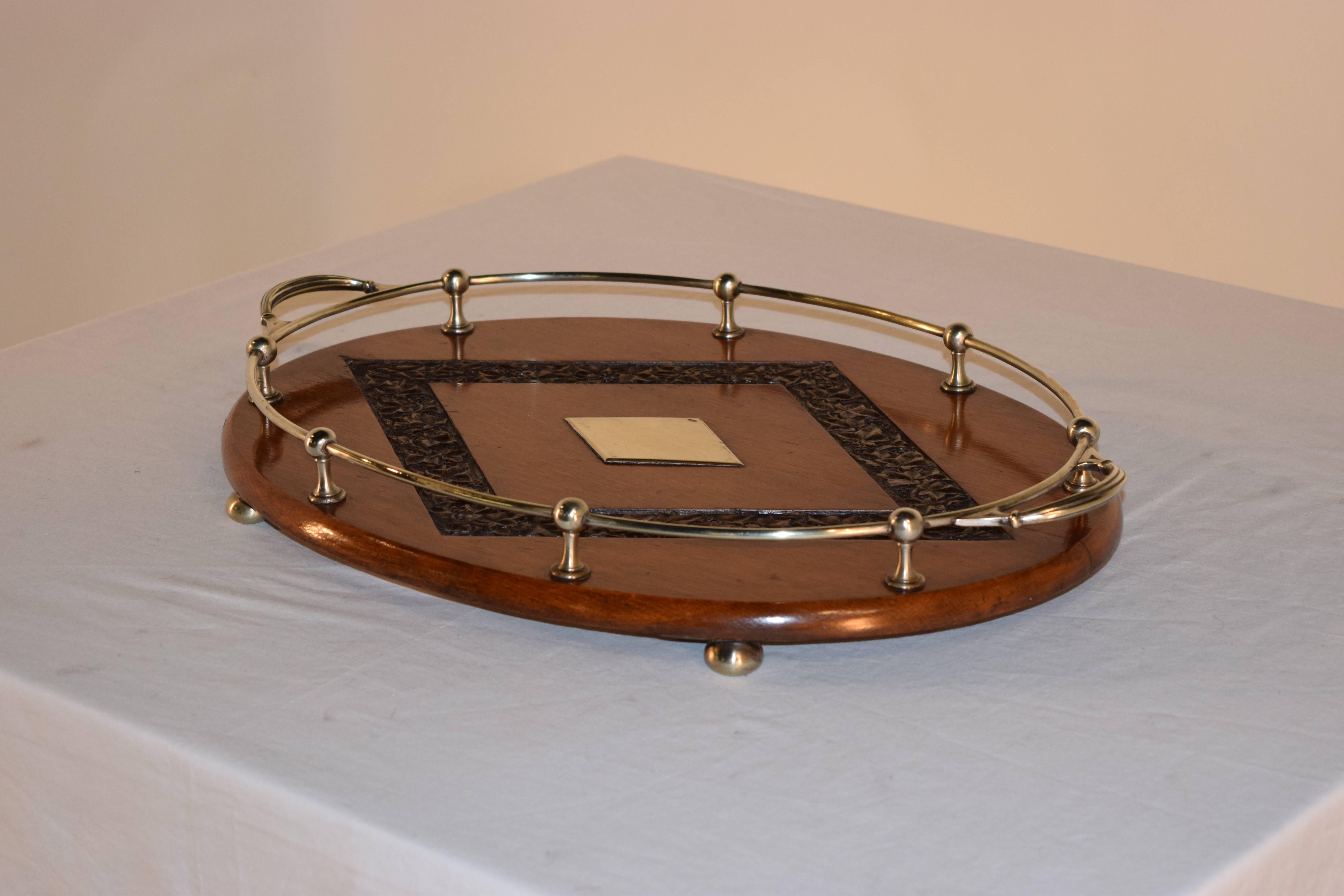 Late 19th century English oak tray with a silver plated gallery and central medallion, surrounded by a hand-carved diamond shaped border. Raised on silver plated bun feet.
