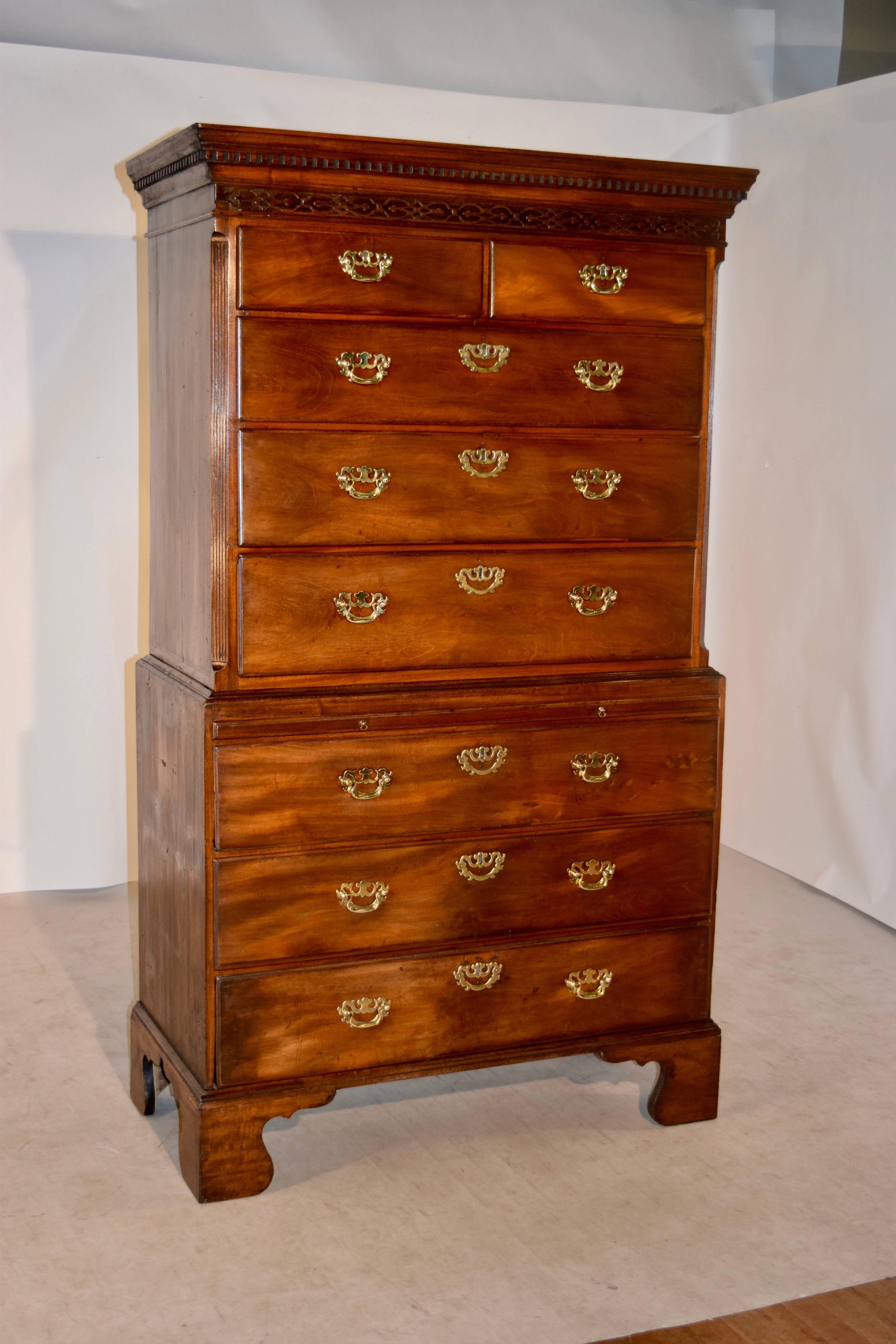 18th century chest on chest from England. There is a dental molding surrounding the top, following down to carved Chippendale fretwork decoration. The upper case has two over three drawers, and rests on the lower case, which has a pull-out candle