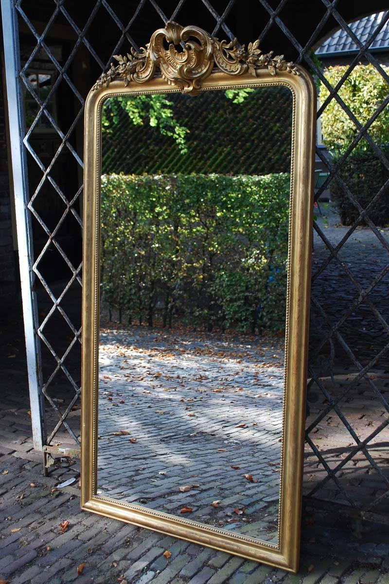 Large 19th century gold gilded mirror engraved with floral decorations and abundant top.
Originates France, dating circa 1880.