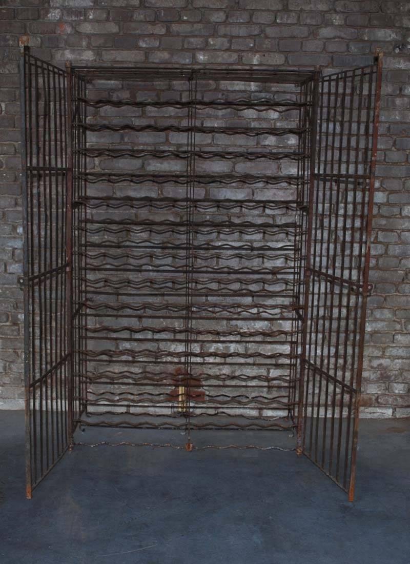 Large wine rack, also known as a wine cage.
This solid iron wine storage rack can take up to 300 bottles.
It can be mounted to the wall or floor and it can be locked with a padlock.
It is painted in rustic brown and has a very warm patina. It is