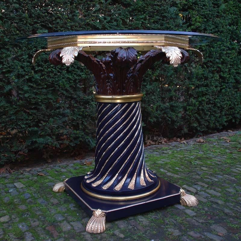 The table has a glass top that is 14mm thick. 
The top is partially etched and gilded.

The base is made of laquered wood with inlay of various copper elements. 
The top of the base is carved as an palmtree.

The base is partially in dark