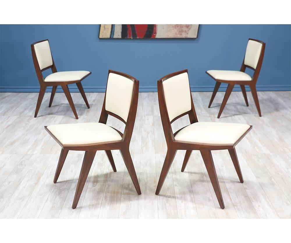 Rare set of 6 dining chairs designed by Dan Johnson for Hayden Hall Furniture in the 1940’s. With its sculptural walnut-stained mahogany frame and new white leather seat rests, this set perfect for the mid century enthusiast.