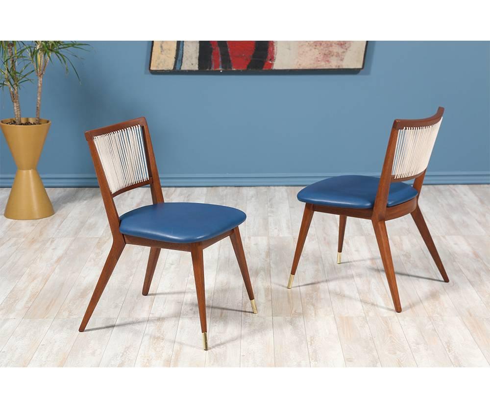 Mid-Century Modern dining chairs designed and manufactured in the United States in the 1960’s. These newly refinished chairs are sculpted with walnut frames and capped with brass sabots at the front legs. The interior foam has been replaced and