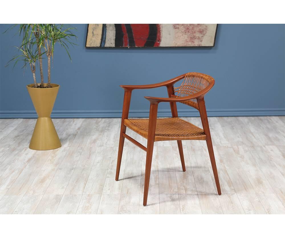 Classic Bambi armchair designed by Rolf Rastad and Adolf Relling for Gustav Bahus in Norway in 1955. Crafted with sculpted teak, this beautiful design features tapered legs and shows various shades of patina on the original woven cane seat rest.
