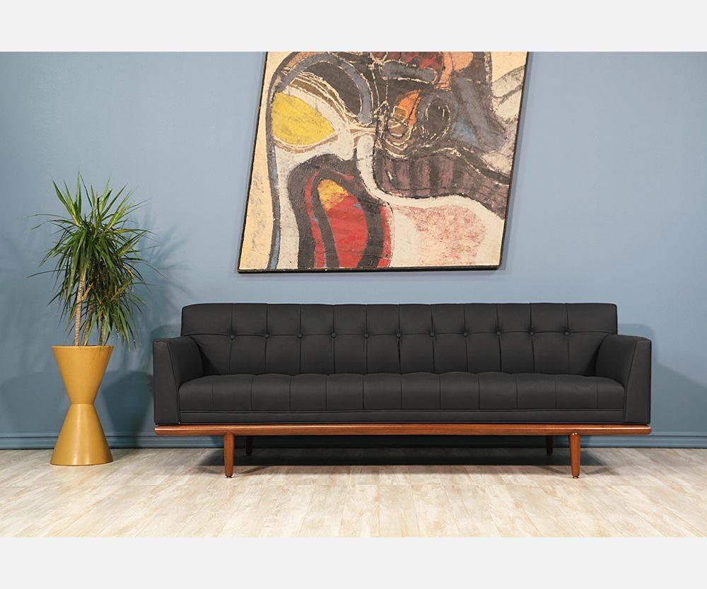 Mid-Century tufted black leather sofa. Designer: Unknown.
Manufacturer: Unknown.
Period/style: Mid-Century Modern.
Country: United States.
Date: 1960s.

Dimensions: 27.75″ H x 79″ W x 29.75″ D.
Seat height: 15.5″.
Materials: Walnut and