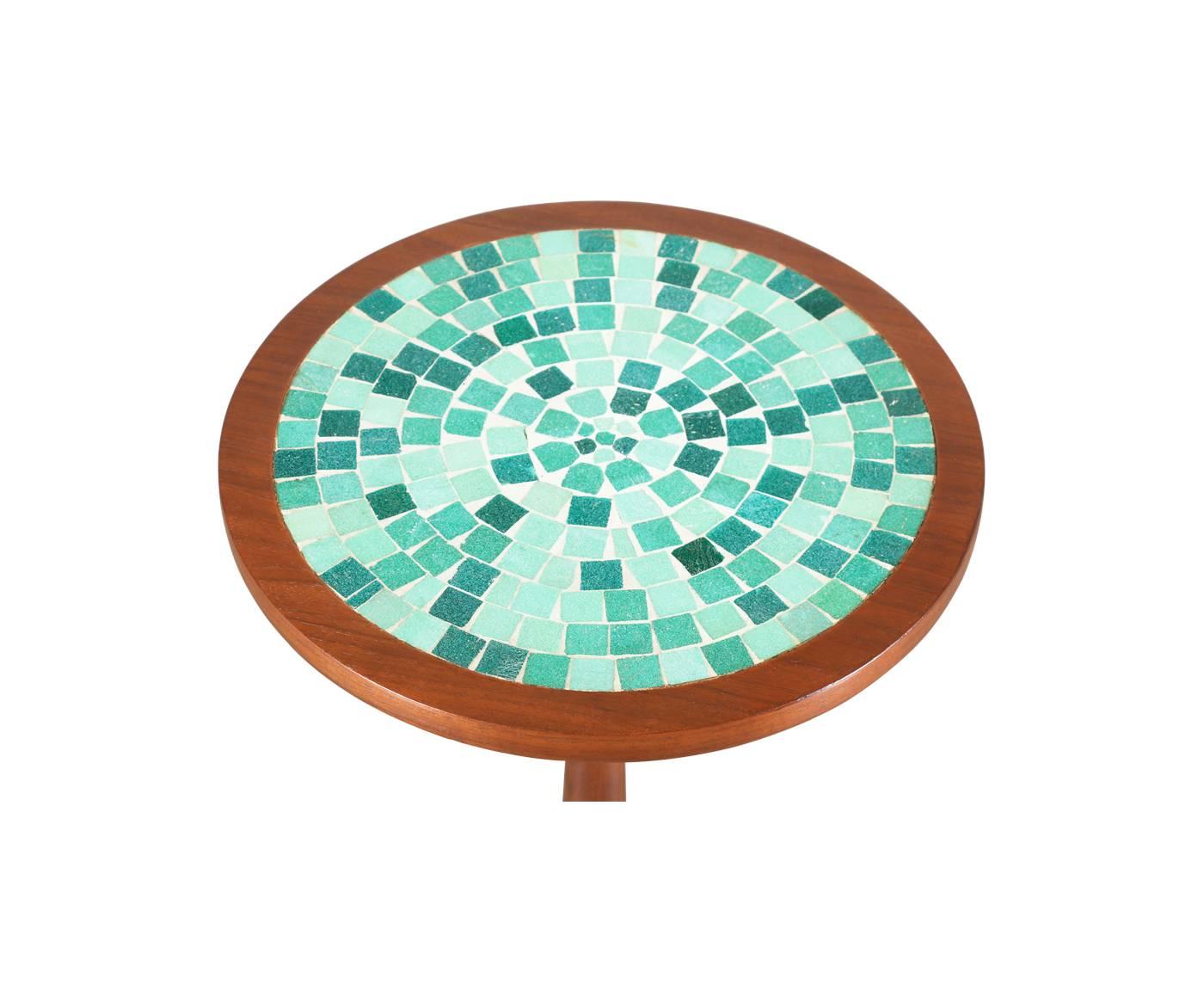 Mid-Century walnut tulip side table with teal blue tile top. Designer: Unknown.
Manufacturer: Unknown.
Period/style: Mid-Century Modern.
Country: United States.
Date: 1950s.

Dimensions: 19″ H x 15″ W.
Materials: Walnut, mosaic