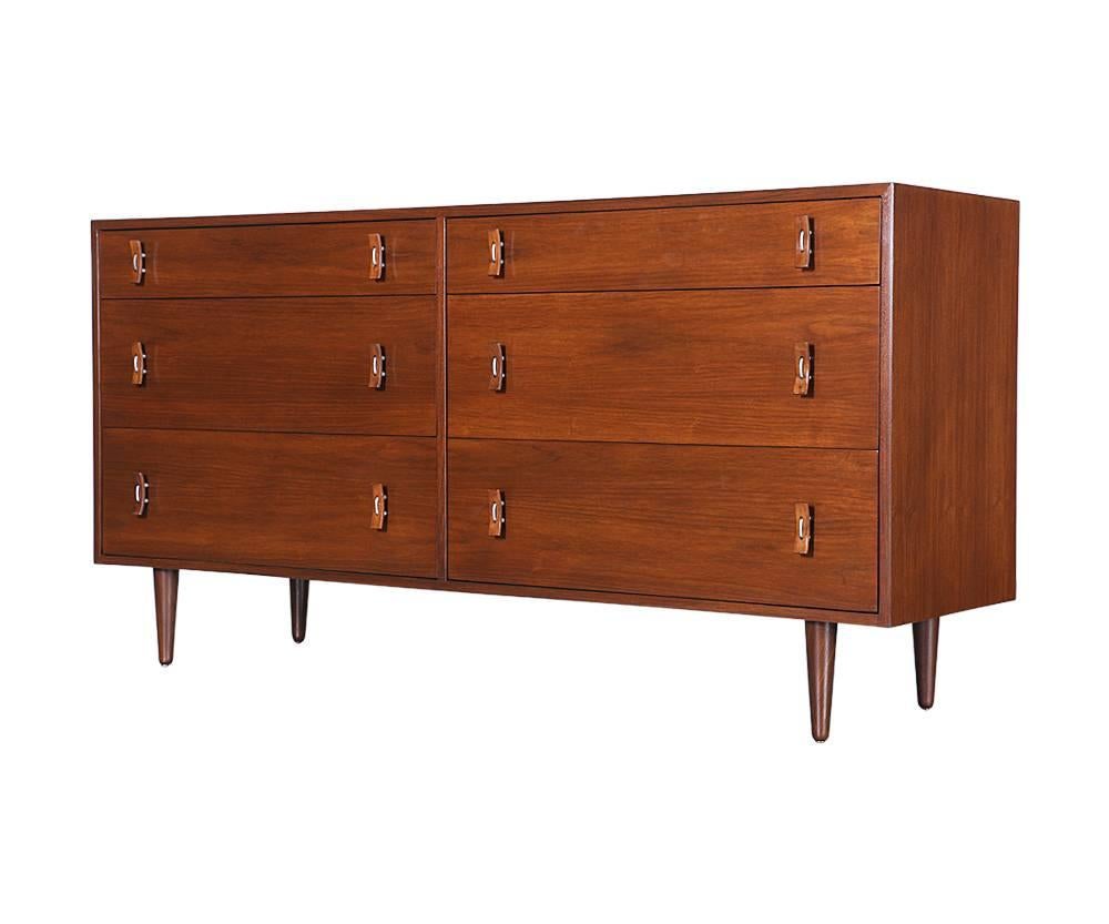 Designer: Stanley Young
Manufacturer: Glenn of California
Period/style: Mid-Century Modern
Country: United States
Date: 1950s

Dimensions: 32.75? H x 64.75? L x 17.75? W
Materials: Walnut, steel pulls
Condition: Excellent, newly