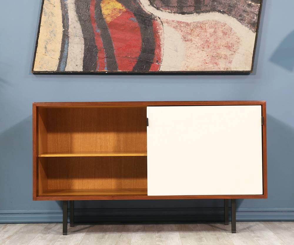 Designer: Florence Knoll
Manufacturer: Florence Knoll Inc.
Period/Style: Mid-Century Modern
Country: United States
Date: 1950s

Dimensions: 27.5? H x 48? W x 17.5? D
Materials: Walnut wood, leather pulls, lacquered doors, iron
