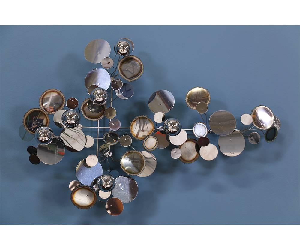 Designer: Curtis Jere
Manufacturer: Artisan House
Period/Style: Mid-Century Modern
Country: United States
Date: 1970s

Dimensions: 24.5? H x 36.5? W 
Materials: Polished and burnished chromed metal disks
Condition: Features a beautiful age
