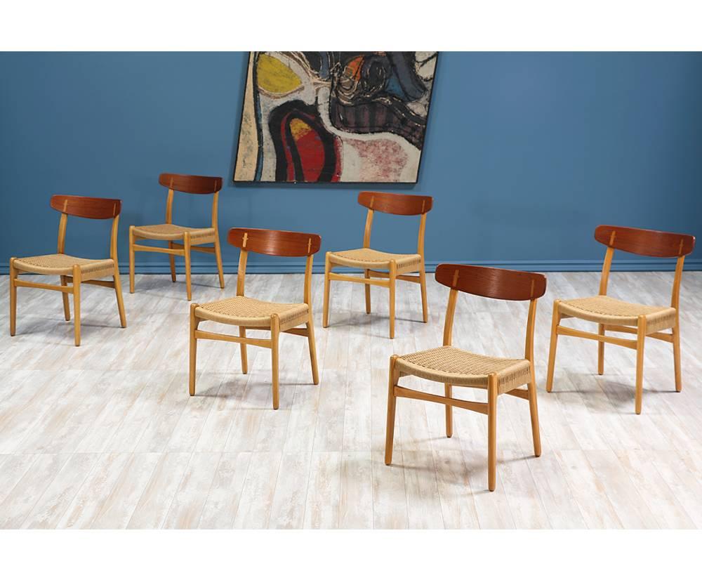 Set of six dining chairs designed by iconic Danish furniture designer Hans J. Wegner for Carl Hansen & Søn in Denmark c. 1950’s. The oak and teak wood frames are in great vintage condition with the Wegnerian joinery details in the backrest, while