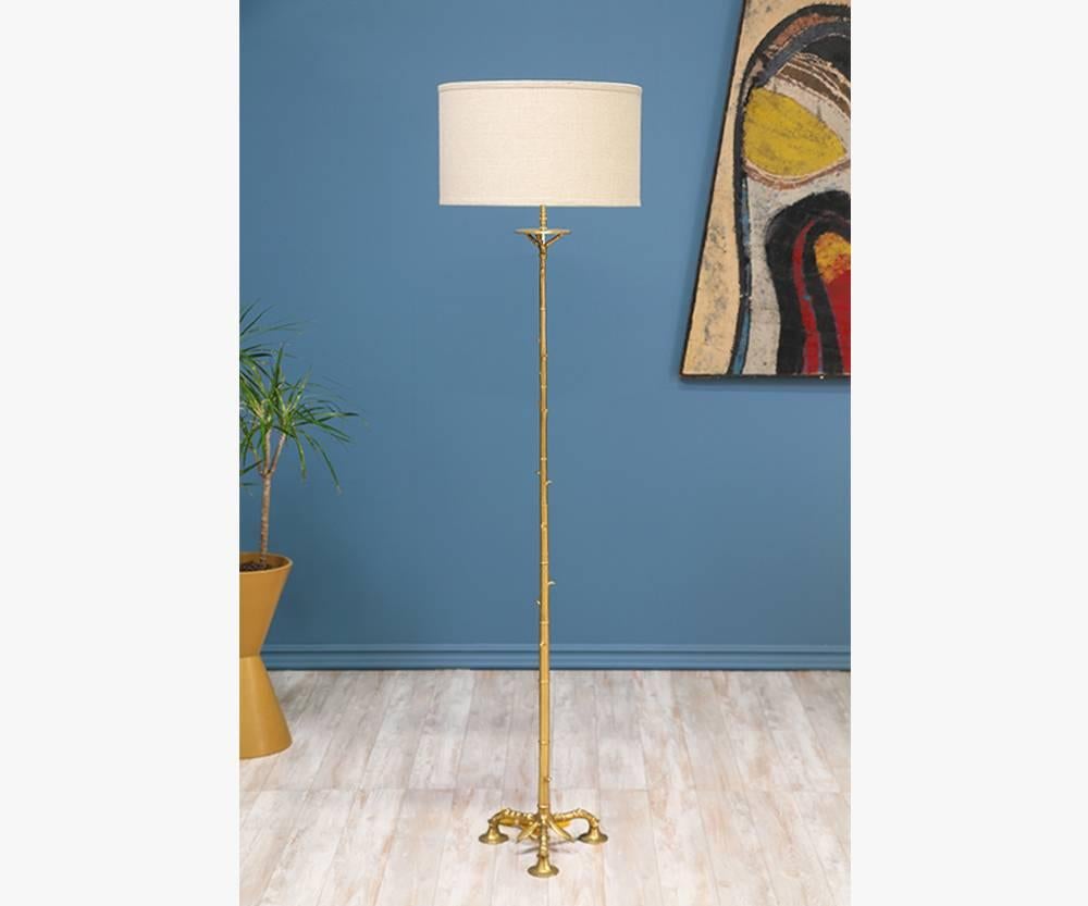 Pair of Mid-Century Modern floor lamps designed and manufactured in the United States in the 1960’s. These tripod leg lamps, made to resemble bamboo, are comprised of solid brass. The details are striking, which include intricately sculpted leaves