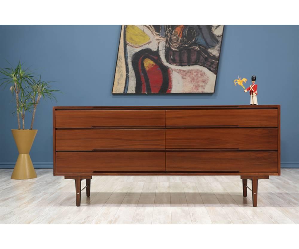 Mid-Century Modern dresser designed by Robert Baron and manufactured in the United States by Glenn of California in the 1950’s. This dresser has six dovetailed drawers that glide smoothly on hard wood rails. With a beautifully rich and warm walnut