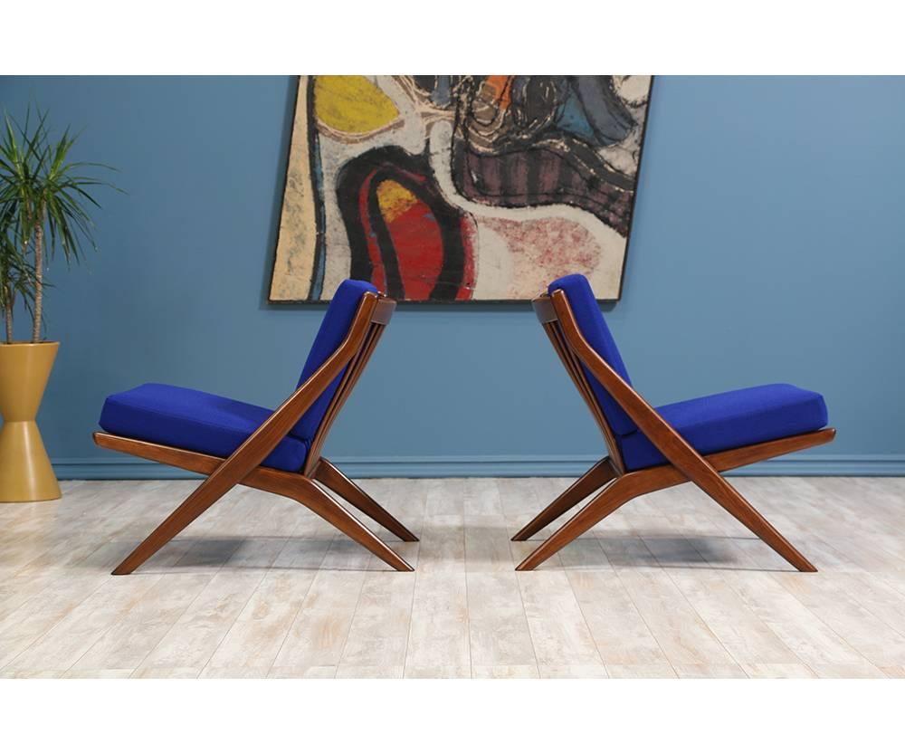 A pair of Lounge Chairs designed by Folke Ohlsson for Dux of Sweden c. 1950’s. Newly refinished and reupholstered with a high-quality tweed fabric in a beautiful blue tone, this Scandinavian modern design features a teak wood scissor-like frame with