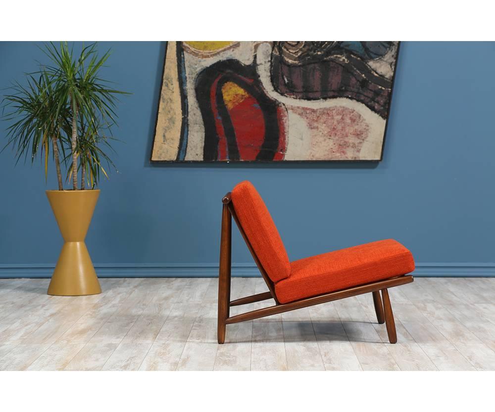 Lounge chair designed by Swedish designer, Alf Svensson, for Dux of Sweden in the 1950’s. A minimalist and clean walnut-stained beechwood frame that sits low to the ground and features newly reupholstered cushions in a speckled orange tweed fabric.