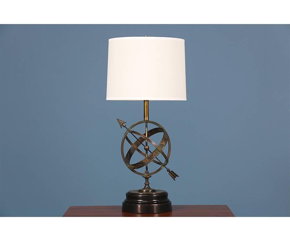 Mid-Century Modern astrological armillary table lamp designed by Chicago based artist Frederick Cooper in the 1970’s. This beautiful item is casted in bronze, features delicate brass details, and a wood base that is representative of the quality